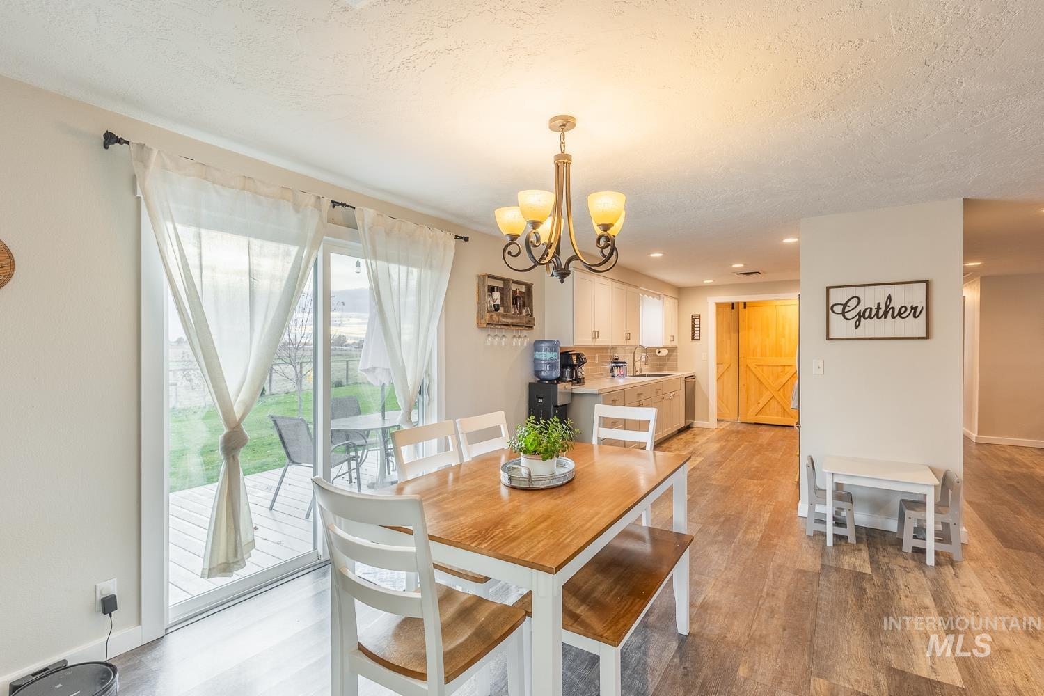 Dining room featuring light wood finished floors, a chandelier, a textured ceiling, and recessed lighting
