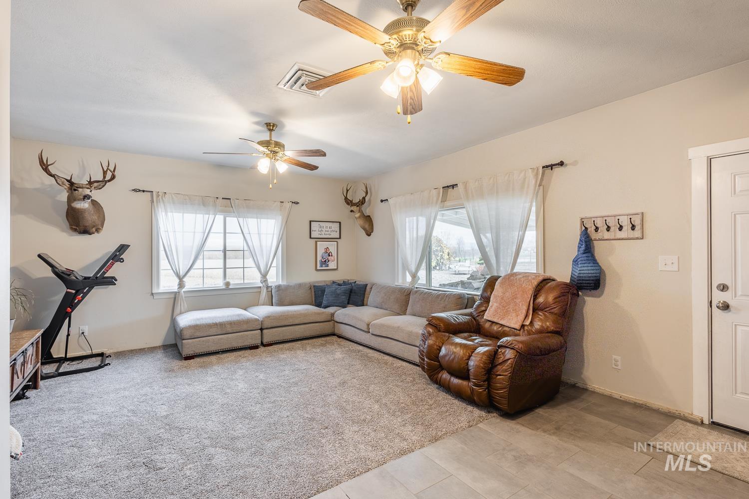 Living area with plenty of natural light and a ceiling fan