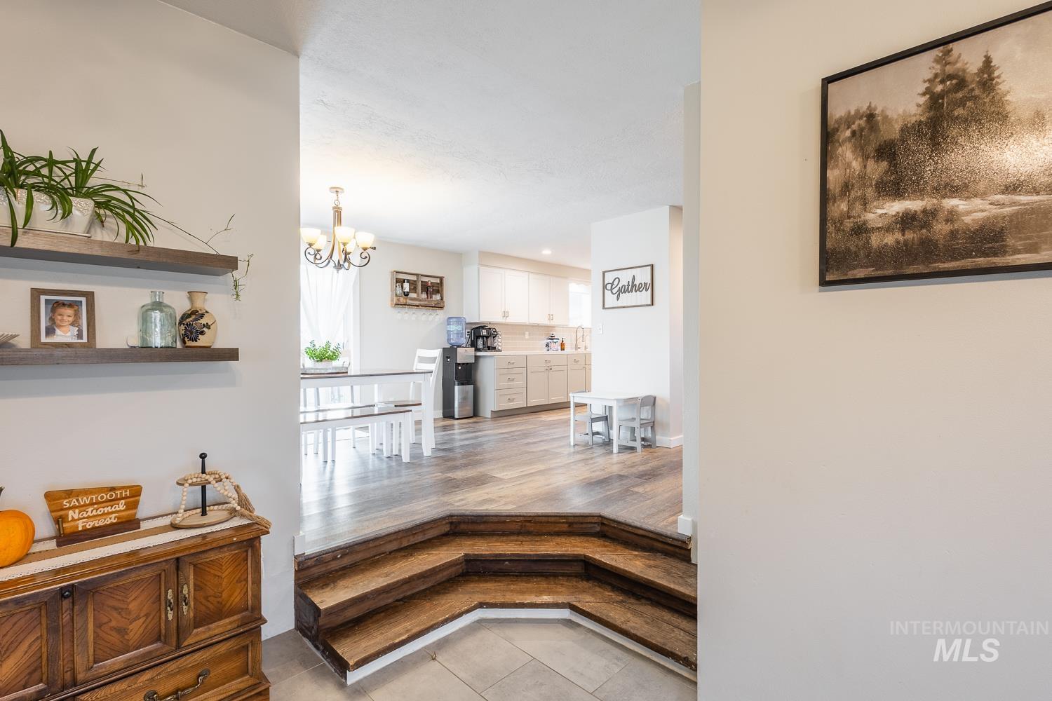 Hall featuring light tile patterned floors, a chandelier, and recessed lighting