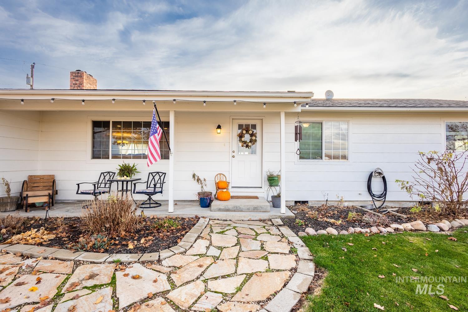 View of front of home featuring a porch, a chimney, and a front yard