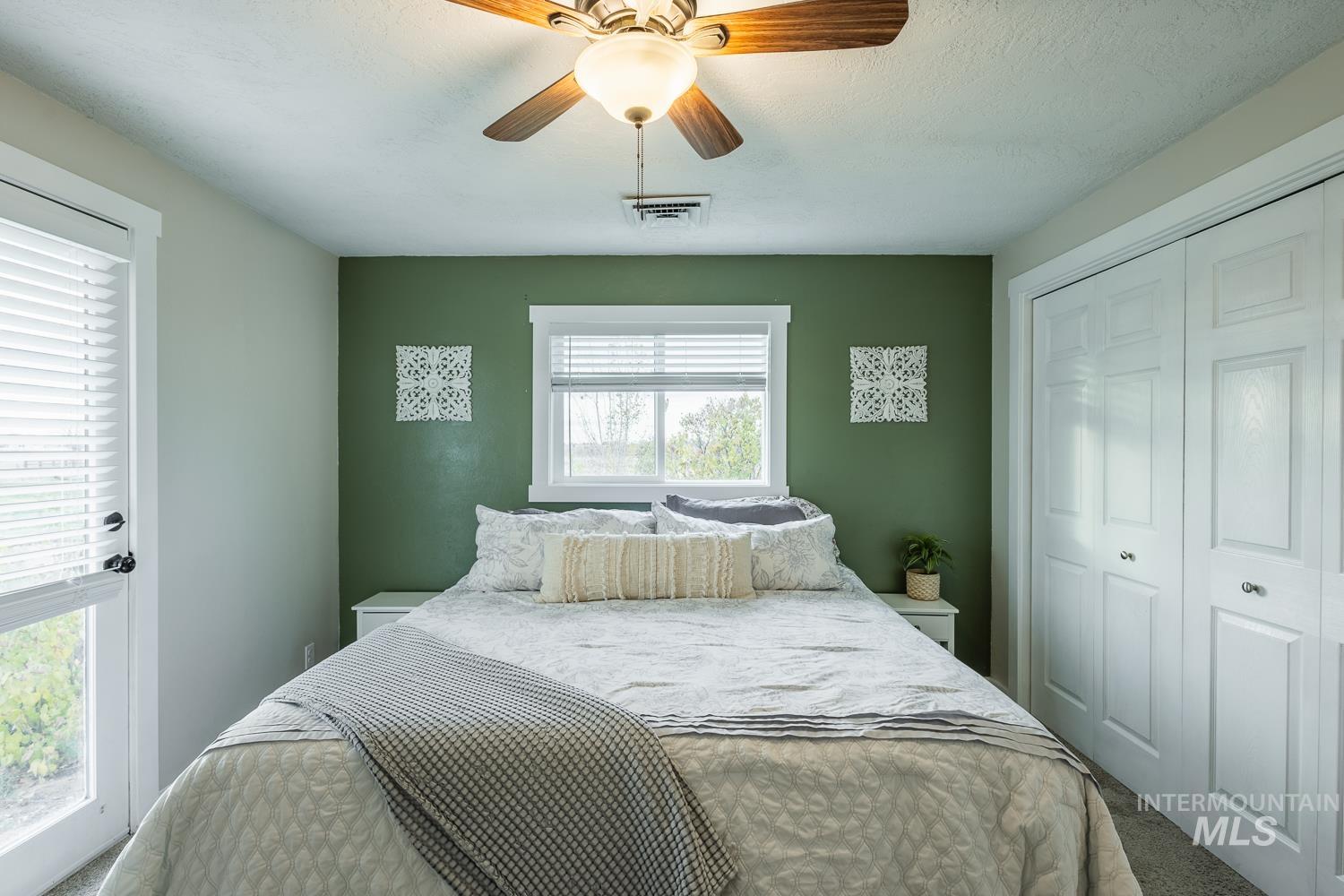 Bedroom featuring a ceiling fan, a closet, and carpet