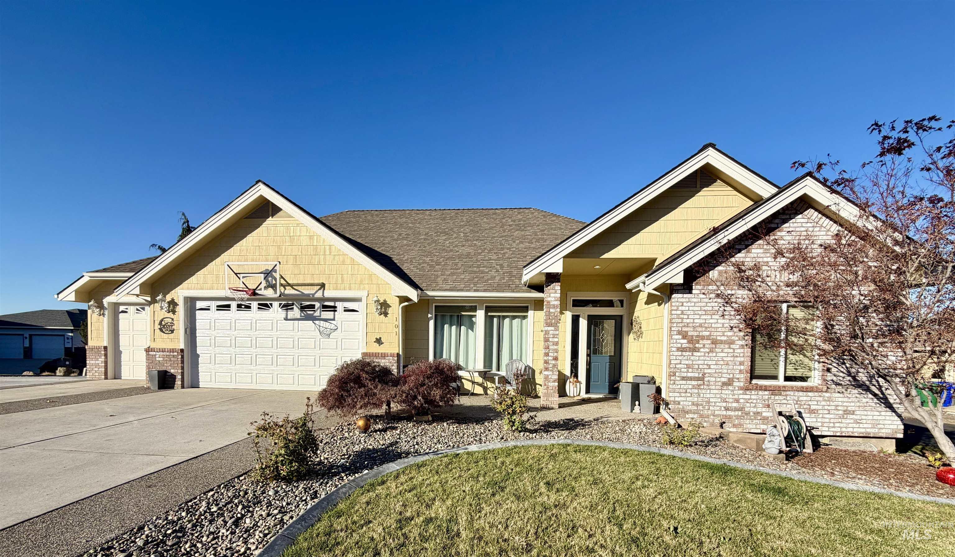 View of front of house with driveway, an attached garage, a front yard, and brick siding