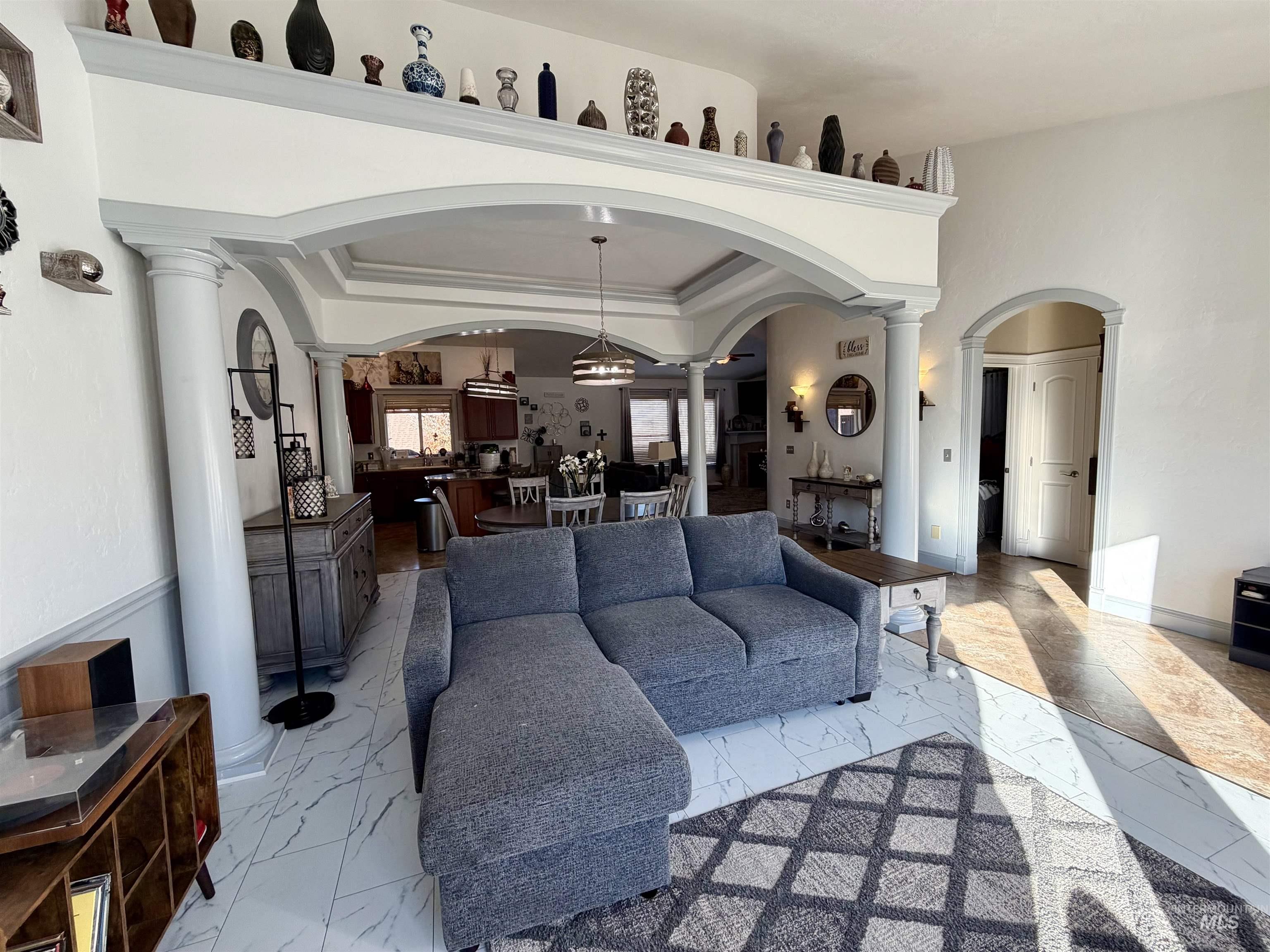 Living area featuring ornate columns and light marble finish flooring