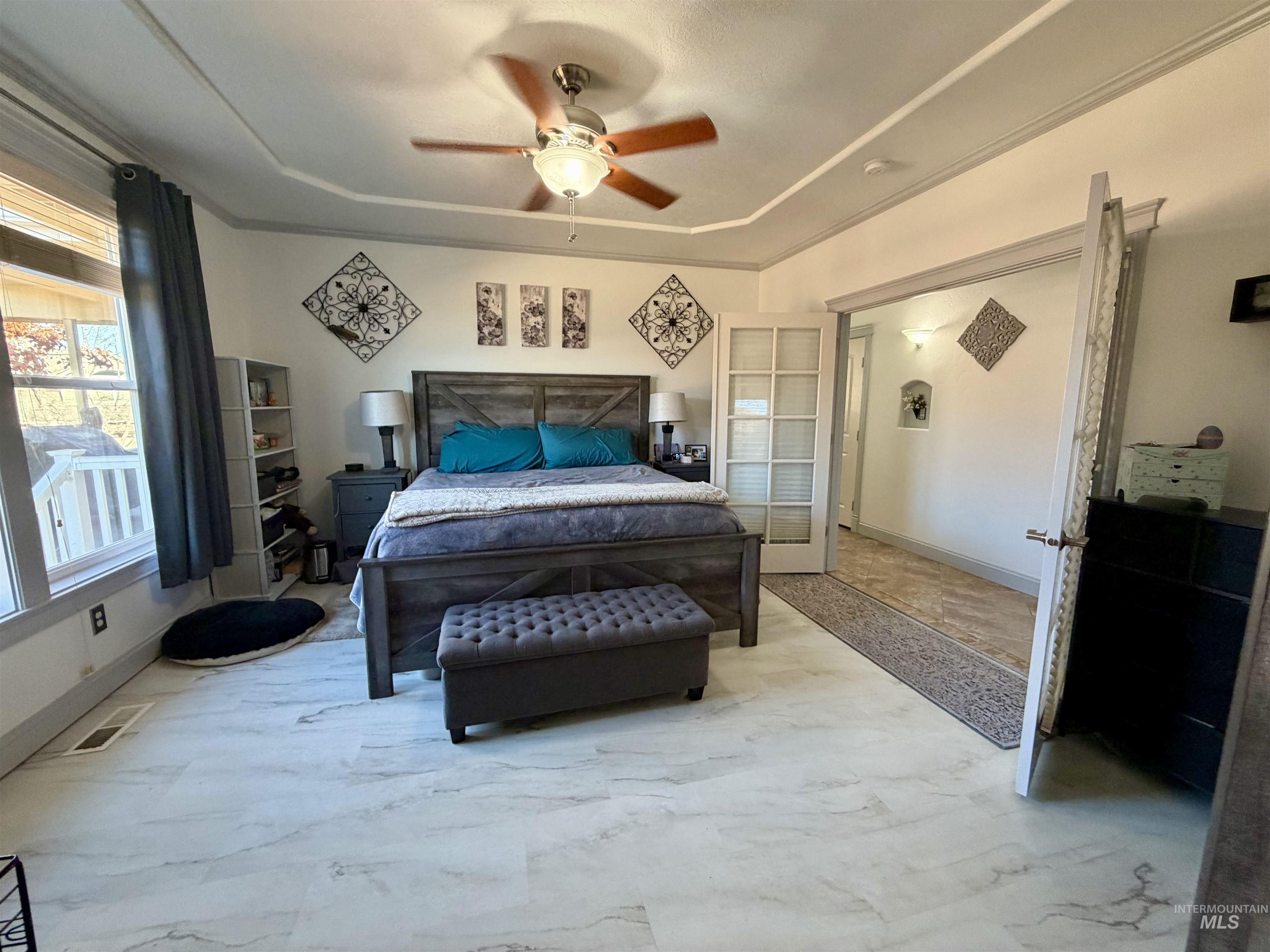 Bedroom with a tray ceiling and a ceiling fan