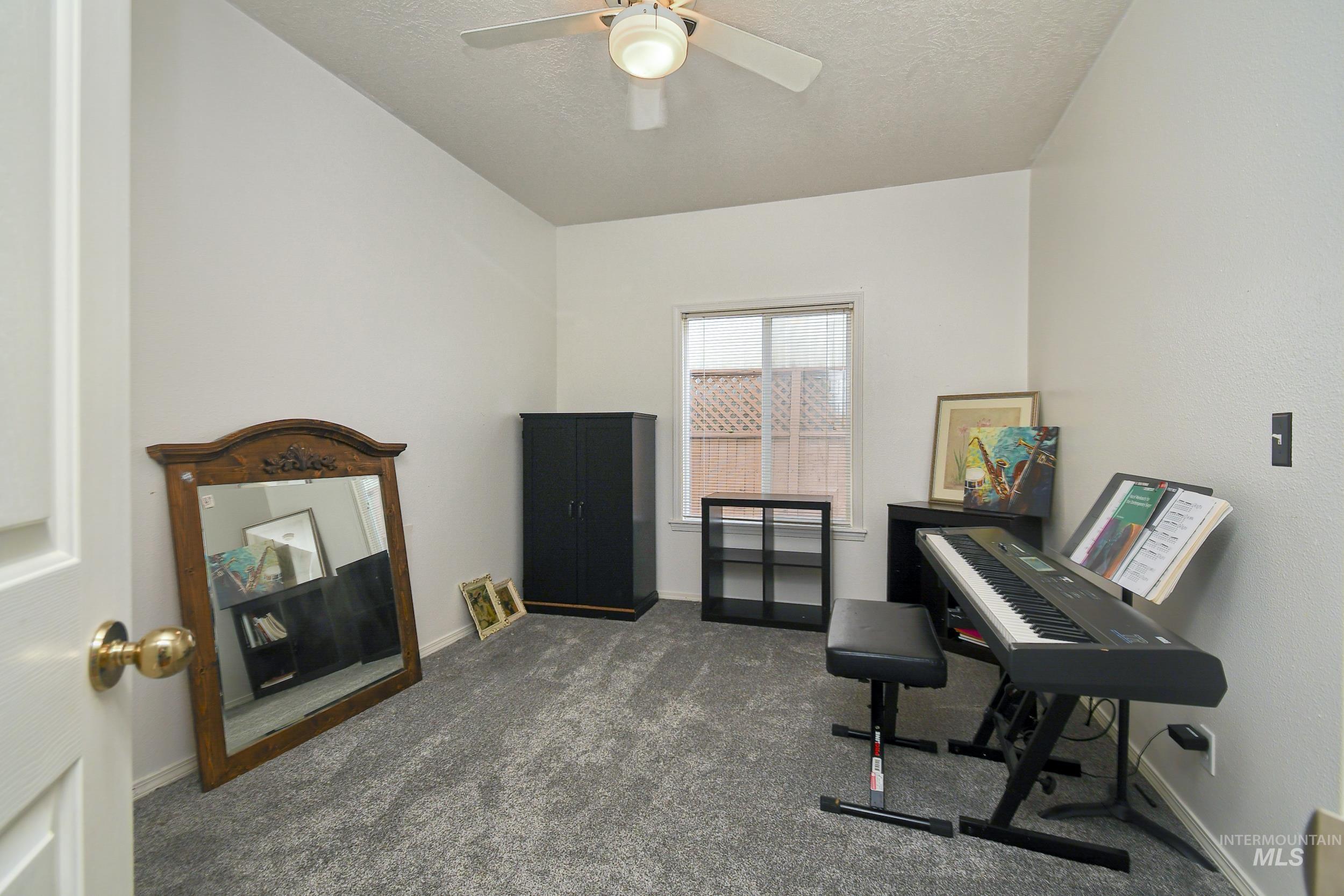 Living area featuring dark carpet and a textured ceiling