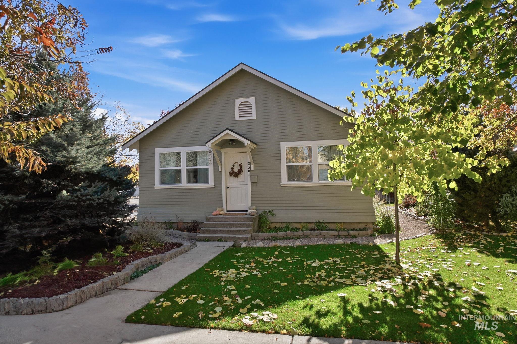 Bungalow-style home featuring a front yard and entry steps