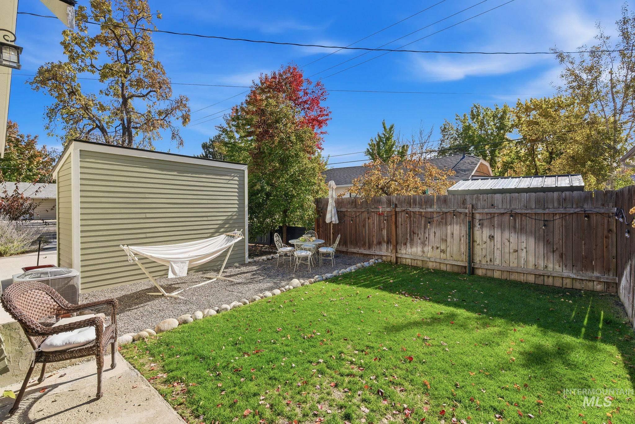 Fenced backyard with an outbuilding