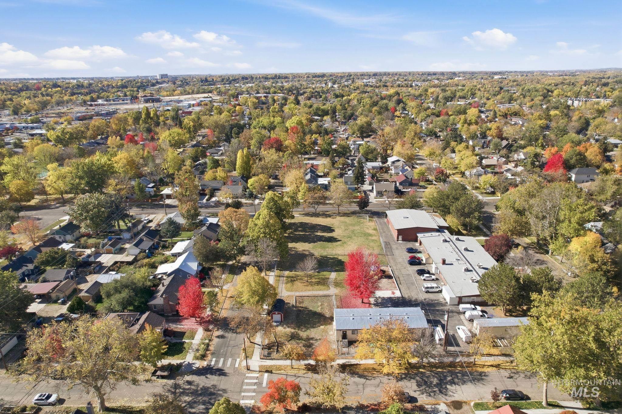 Aerial view of property and surrounding area with nearby suburban area