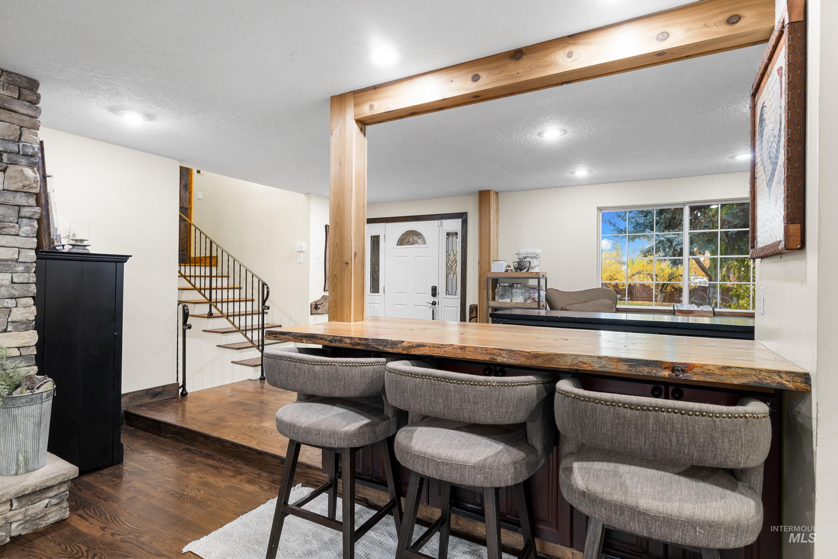 Indoor dry bar with wood counters, dark wood-type flooring, stairs, and recessed lighting