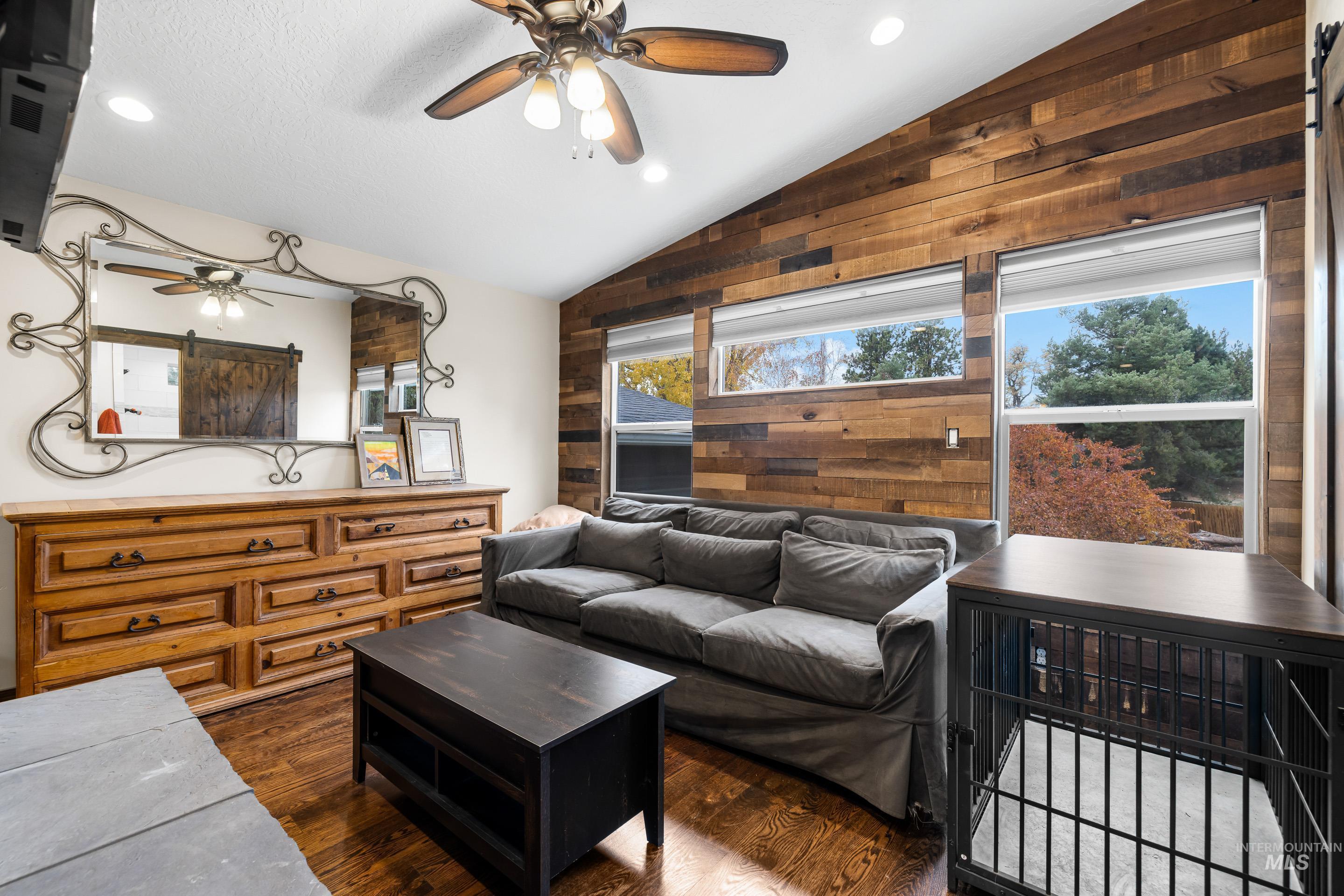 Living room with recessed lighting, vaulted ceiling, dark wood-type flooring, and a ceiling fan