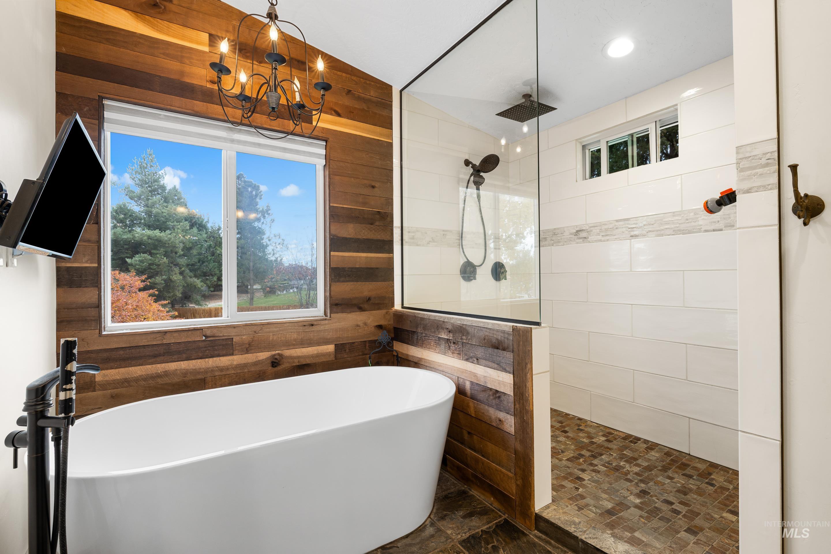 Bathroom featuring walk in shower, a freestanding bath, wood walls, lofted ceiling, and recessed lighting