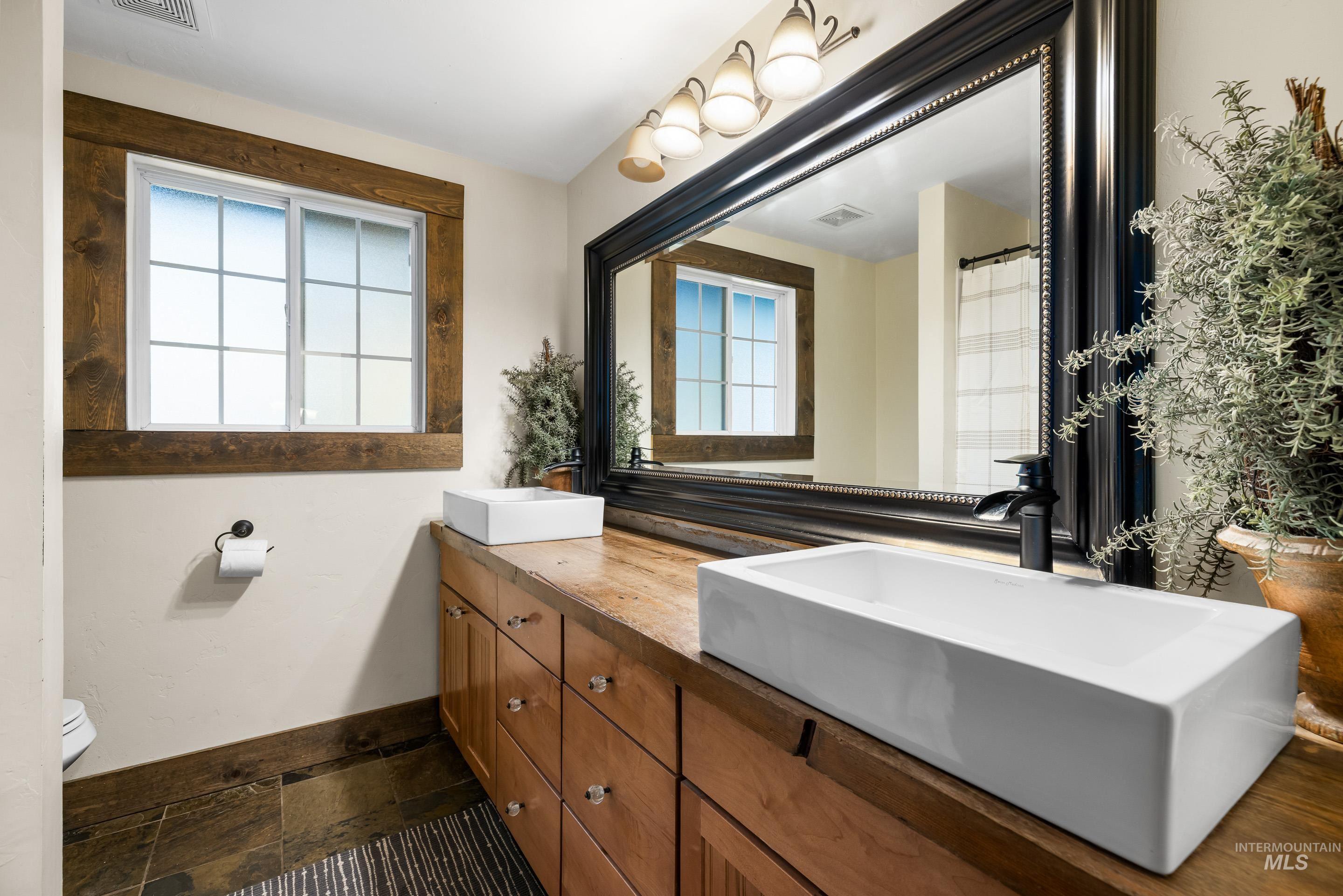 Bathroom with healthy amount of natural light, double vanity, and a shower with curtain