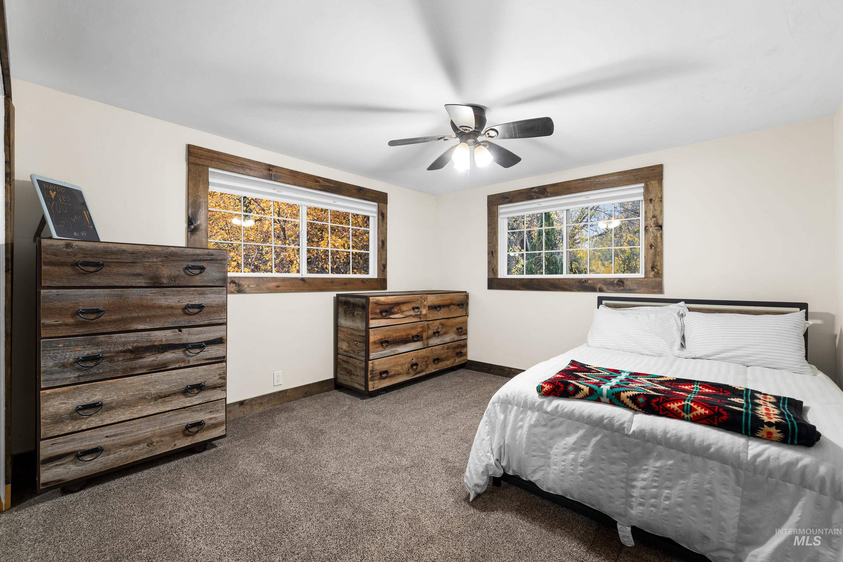 Carpeted bedroom featuring baseboards and ceiling fan