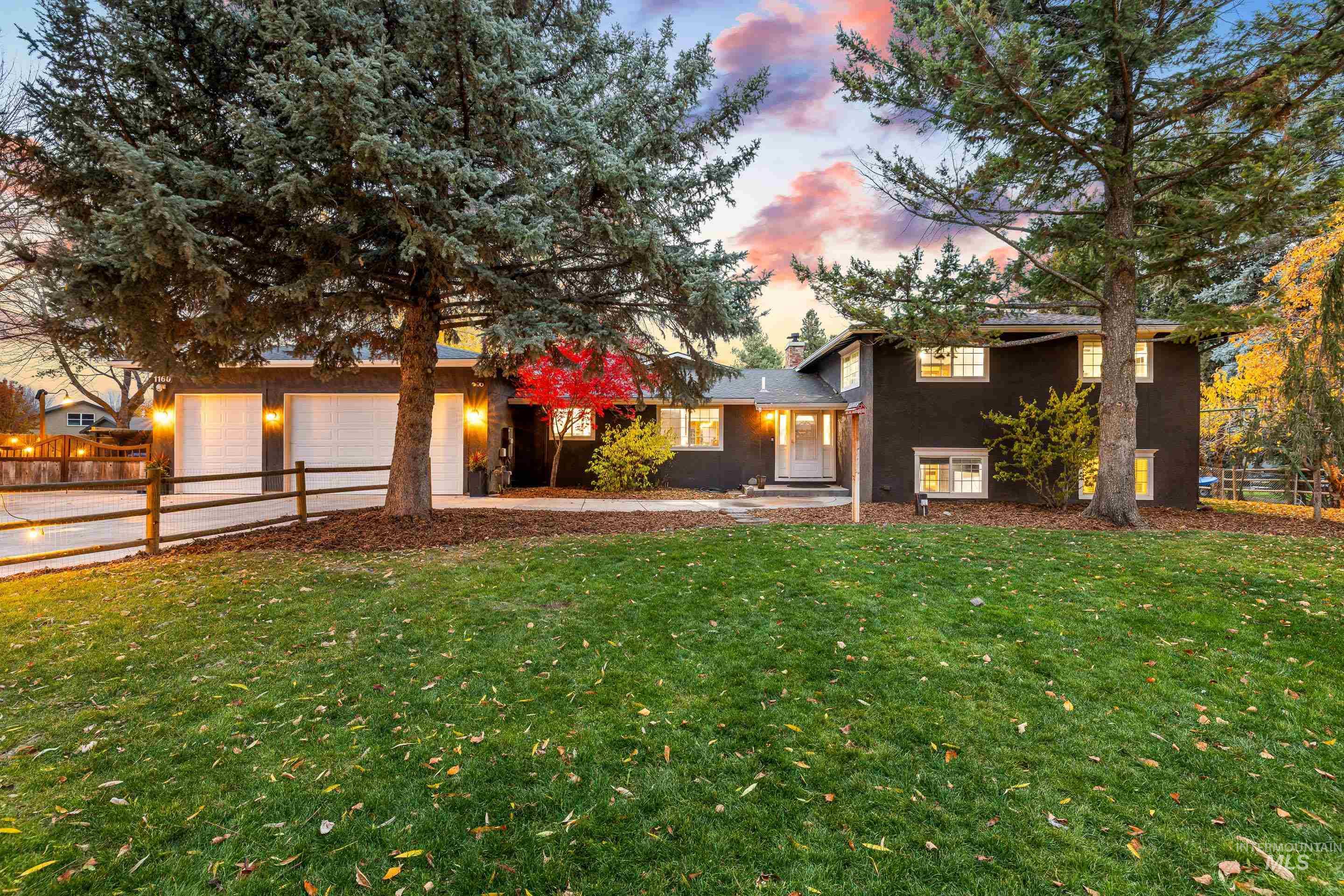 Split level home featuring driveway, a chimney, and an attached garage
