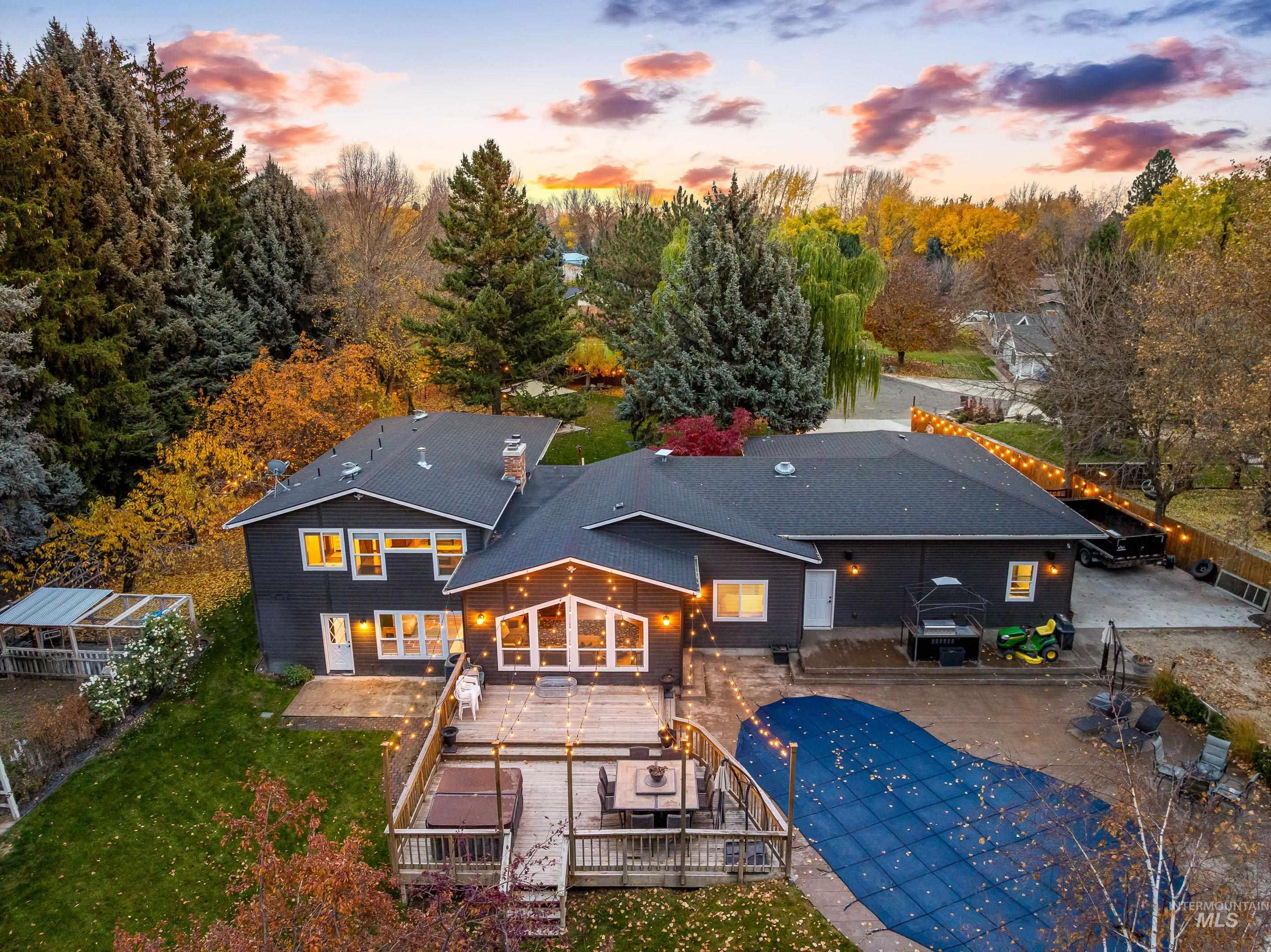 Back of property at dusk with a patio and a wooden deck