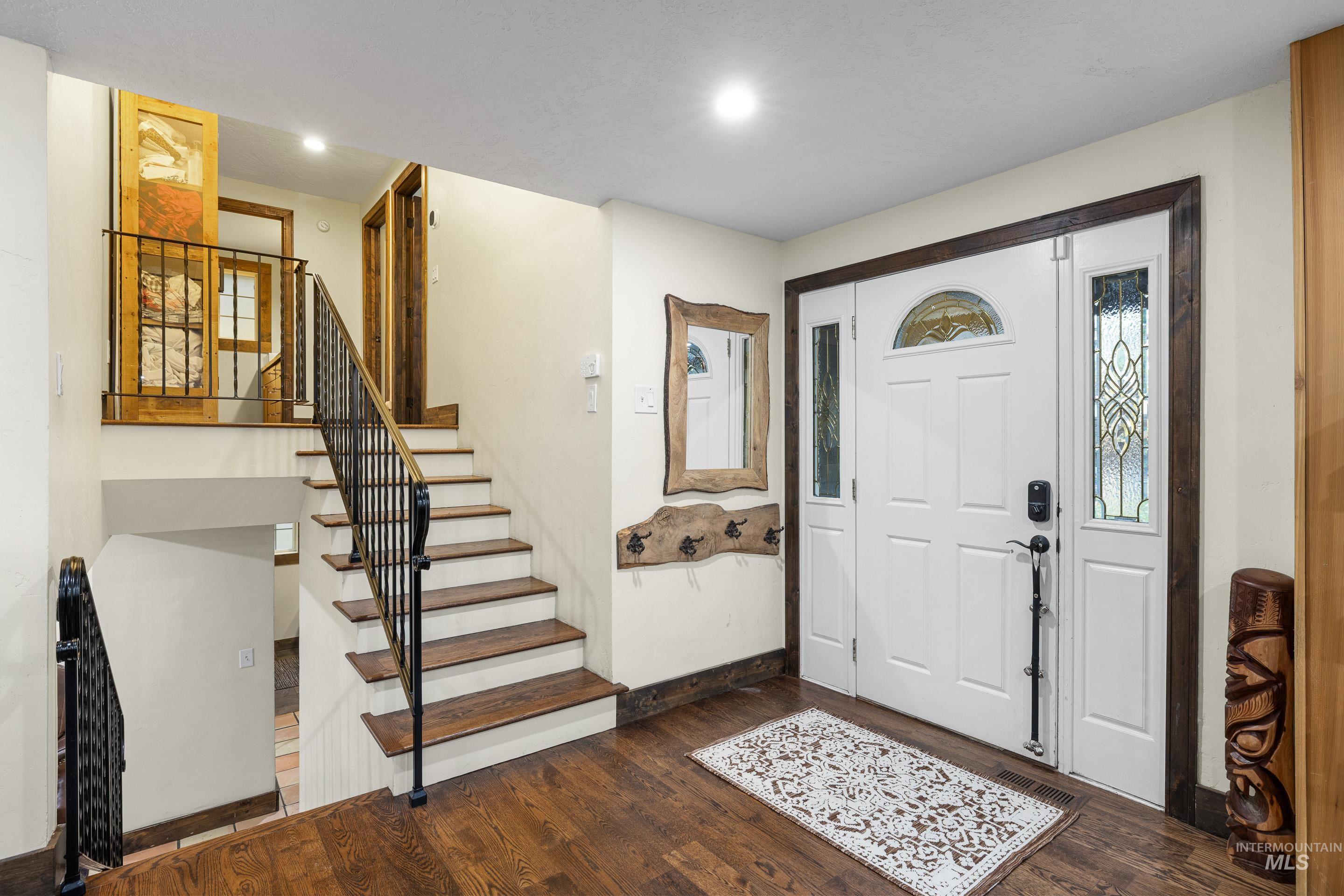Foyer entrance featuring dark wood-style floors, stairway, and recessed lighting