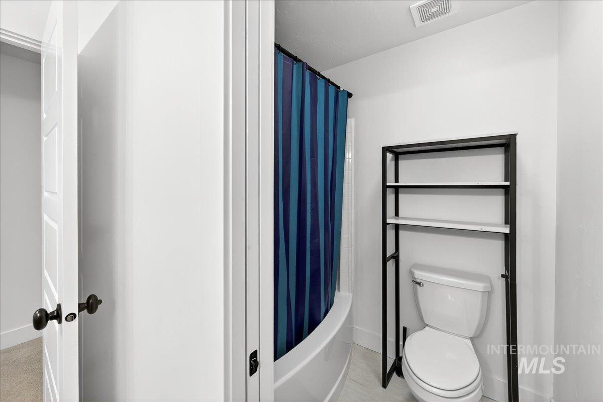 Full bathroom with shower / bath combination with curtain and baseboards