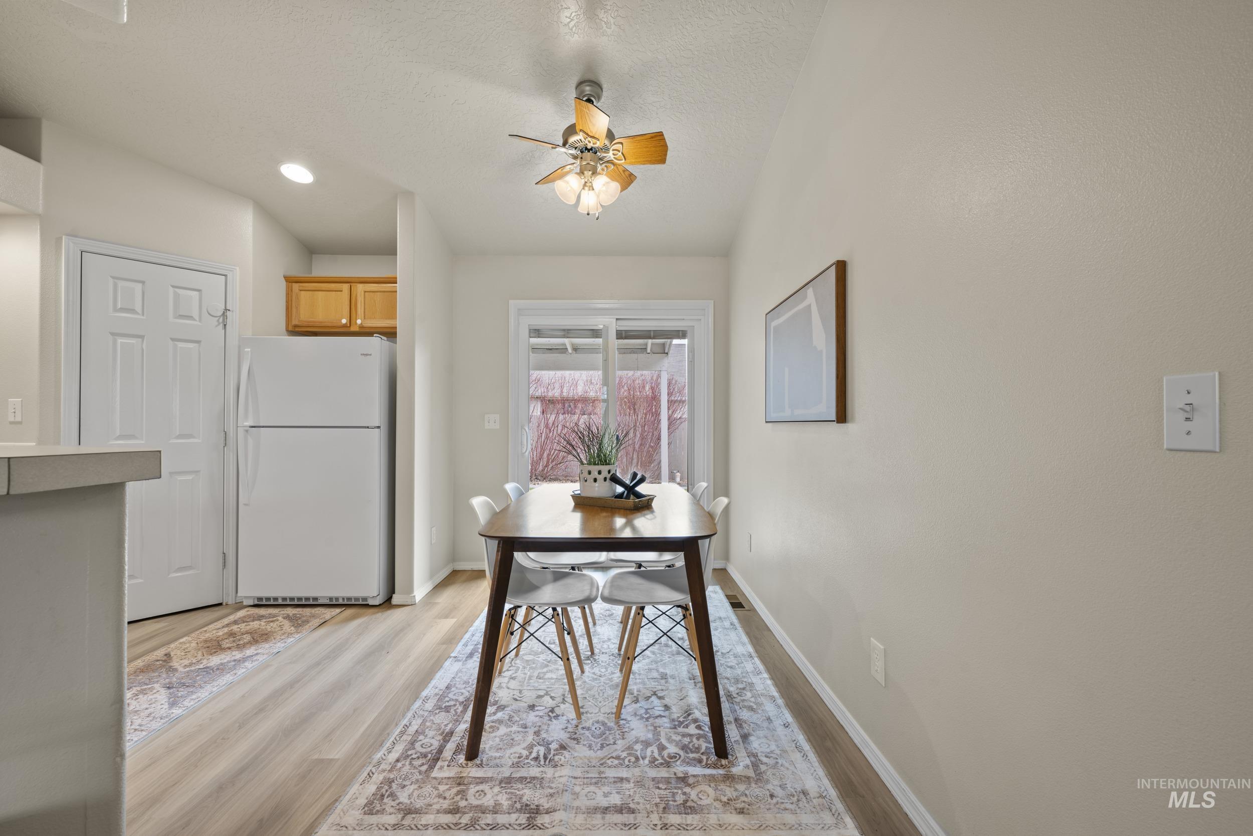 Dining room featuring light wood-style floors, ceiling fan, a textured ceiling, and recessed lighting