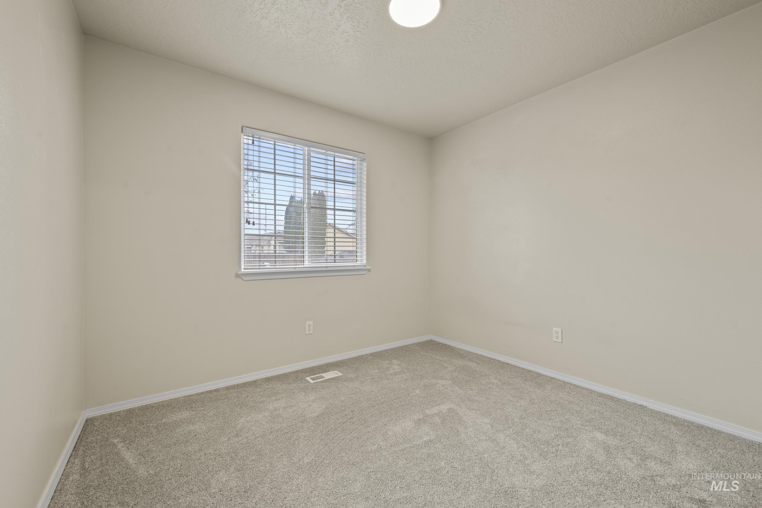 Carpeted spare room with baseboards and a textured ceiling