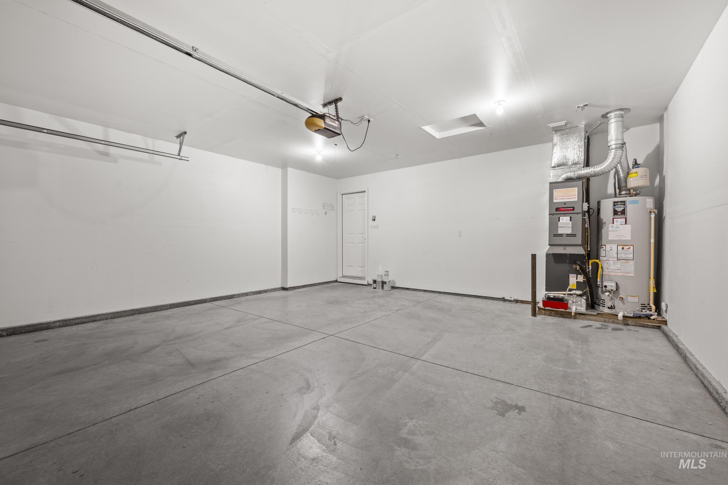 Garage with gas water heater and a garage door opener