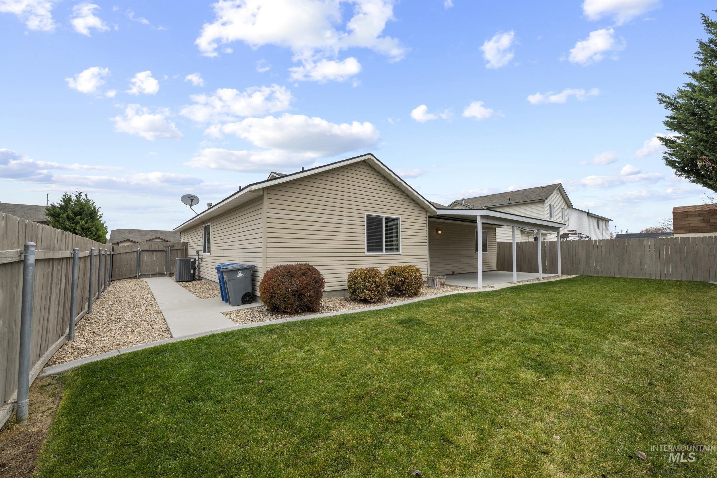 Back of house with a patio, a fenced backyard, and a gate