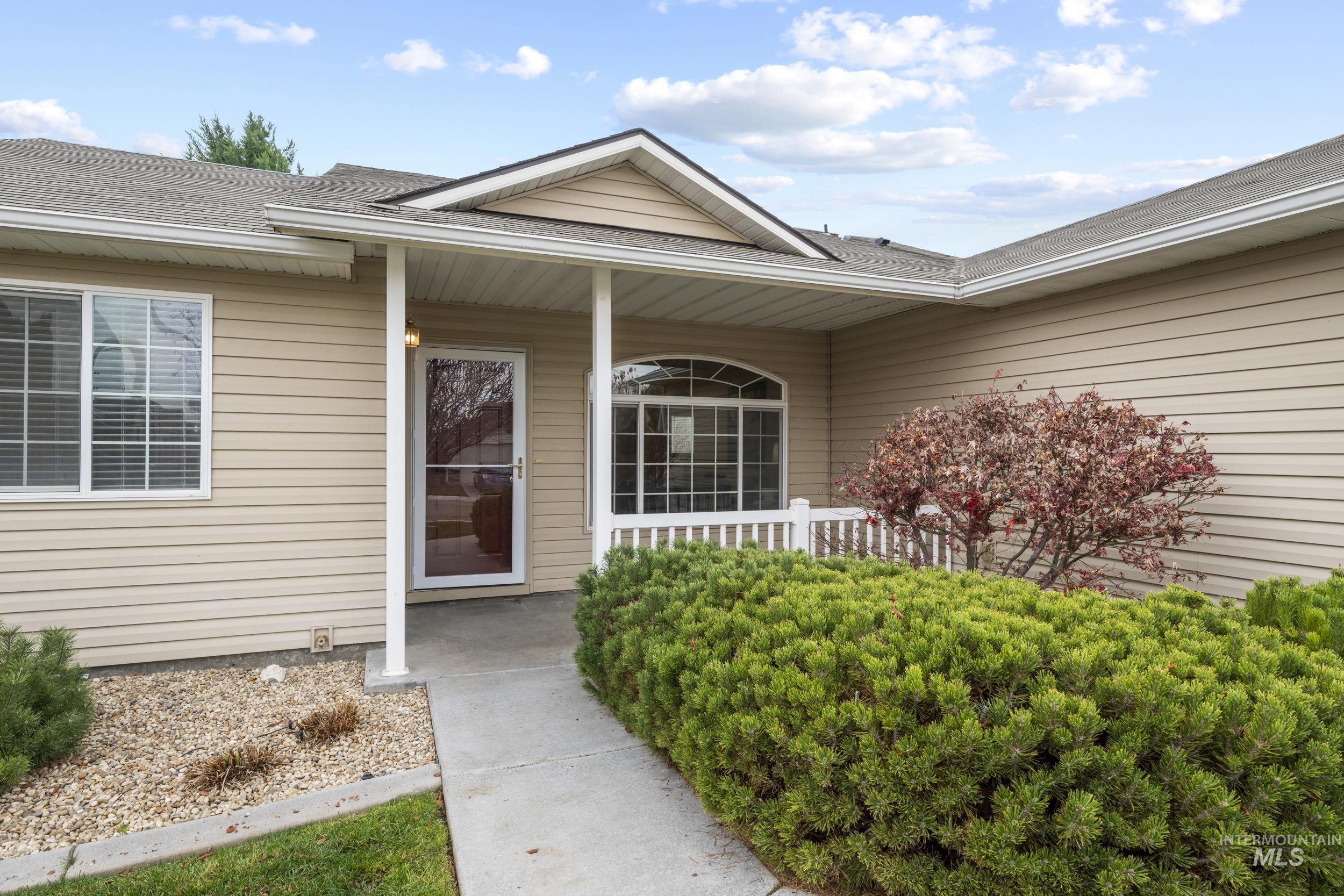 View of exterior entry featuring a porch and a shingled roof