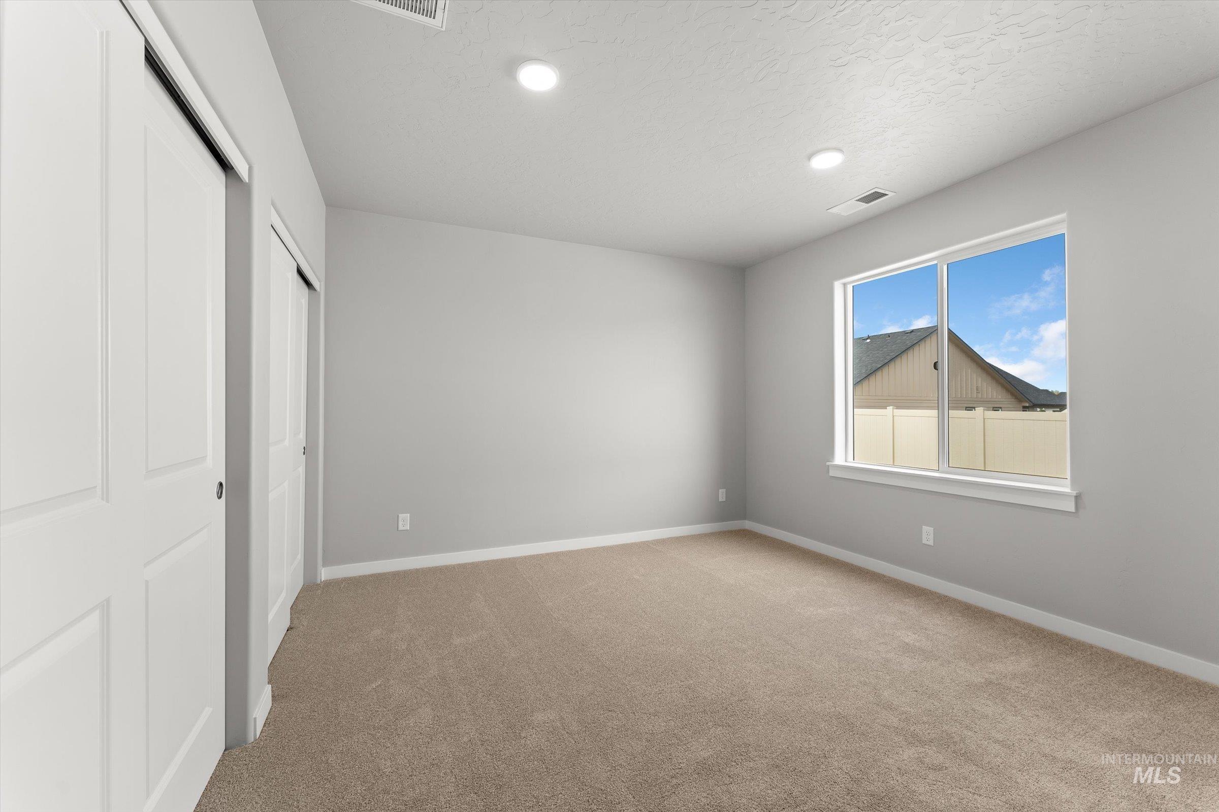 Unfurnished bedroom featuring light colored carpet, recessed lighting, and a textured ceiling
