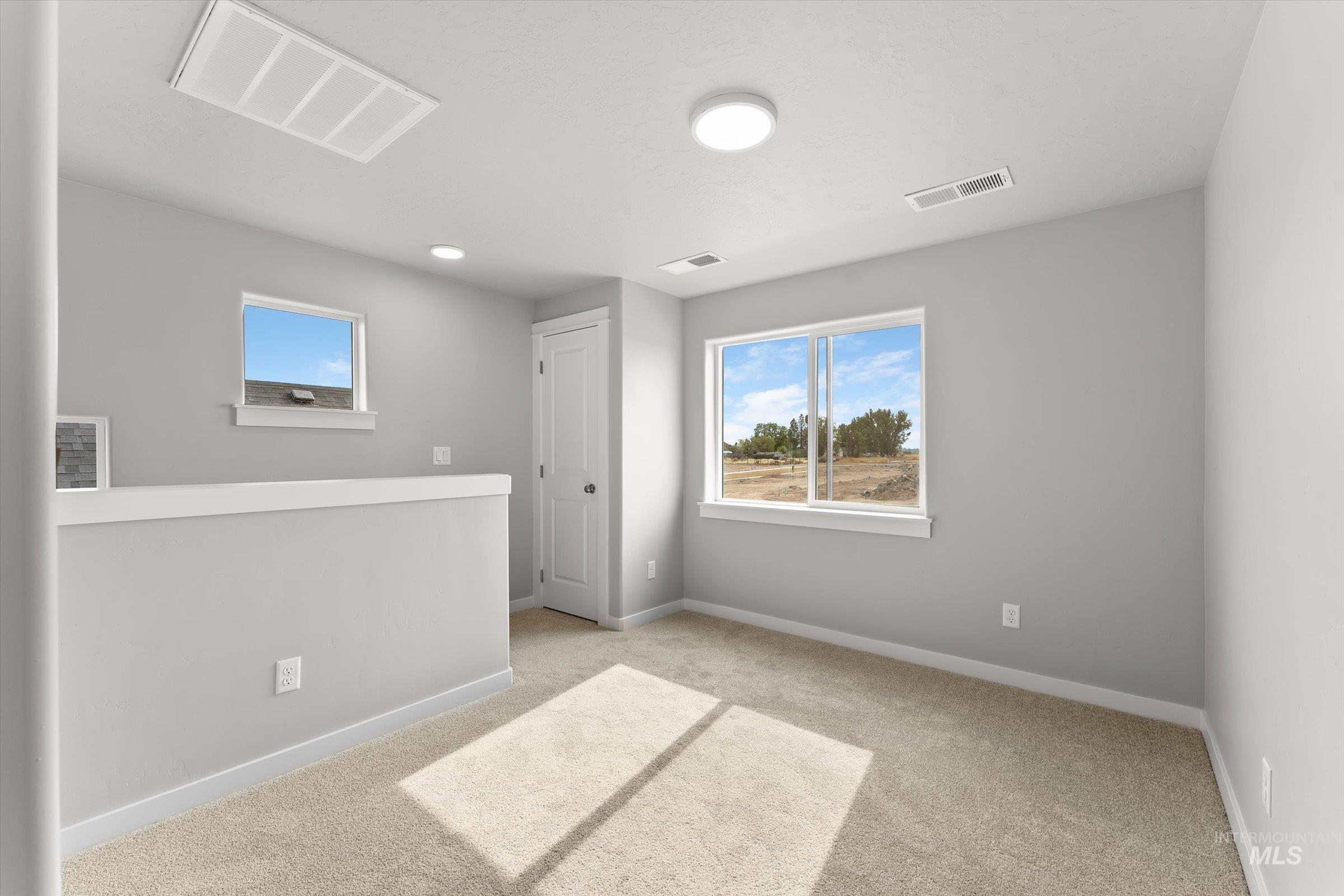 Carpeted spare room with baseboards