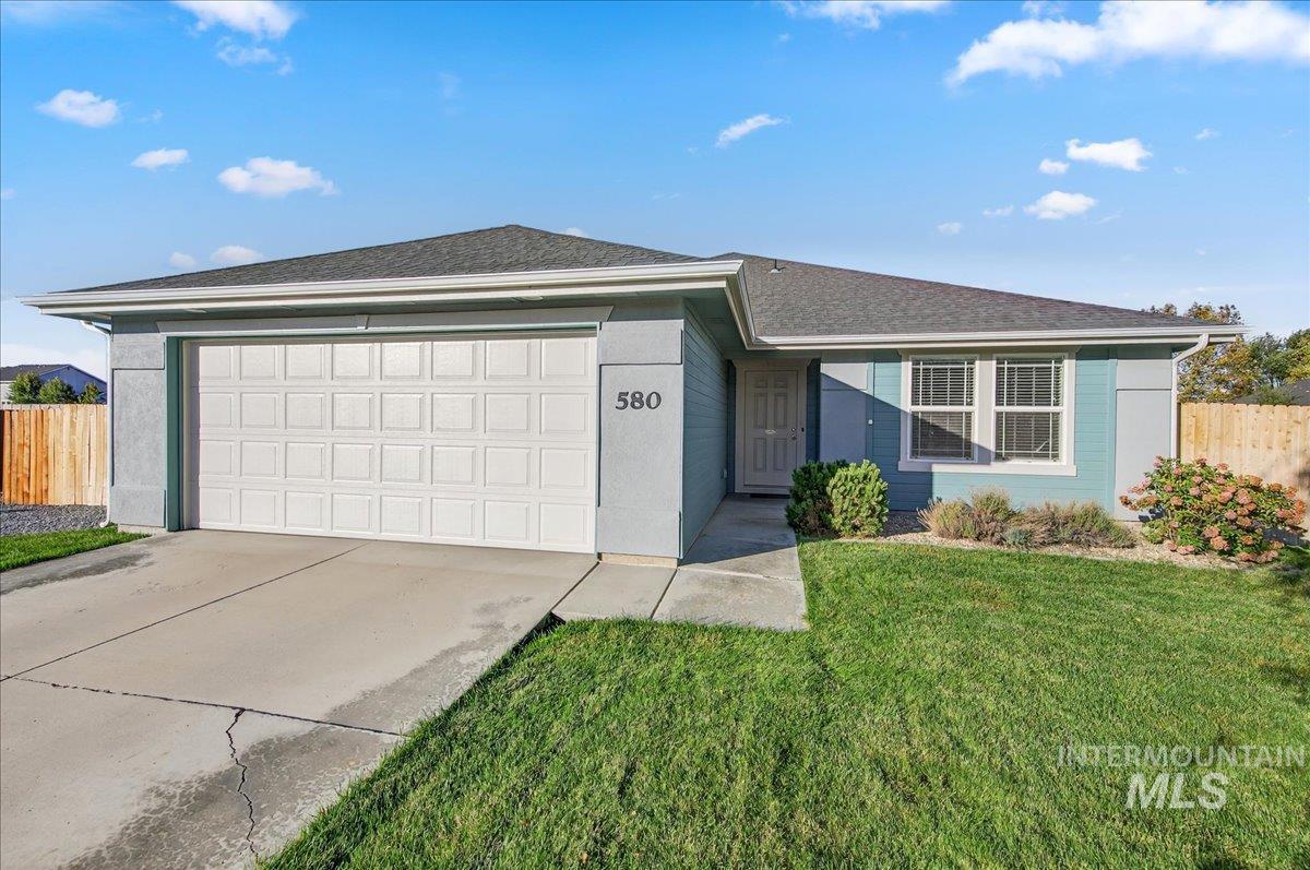 Ranch-style house featuring a garage, roof with shingles, and driveway