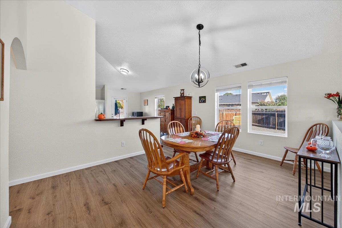 Dining area with wood finished floors and a chandelier