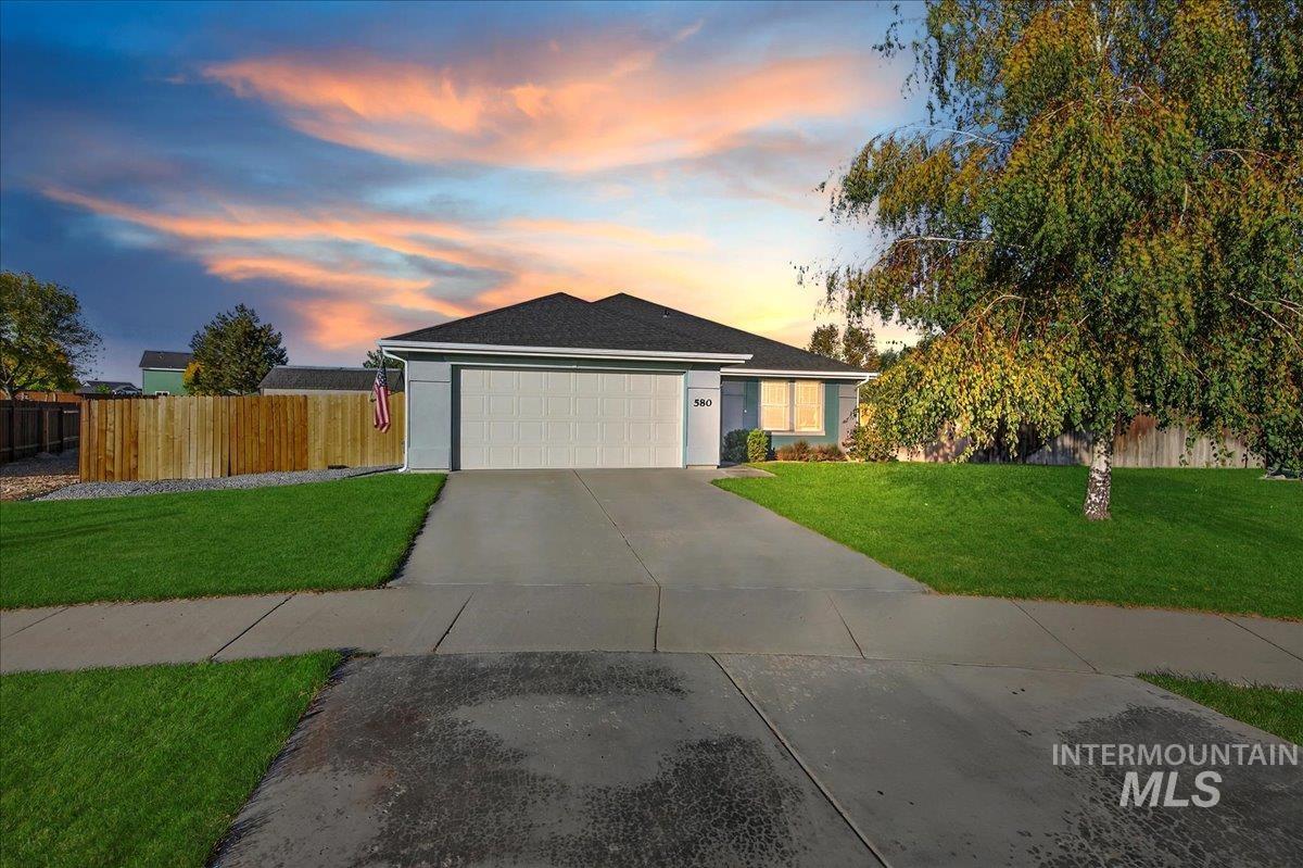 Single story home featuring concrete driveway, an attached garage, stucco siding, and a shingled roof