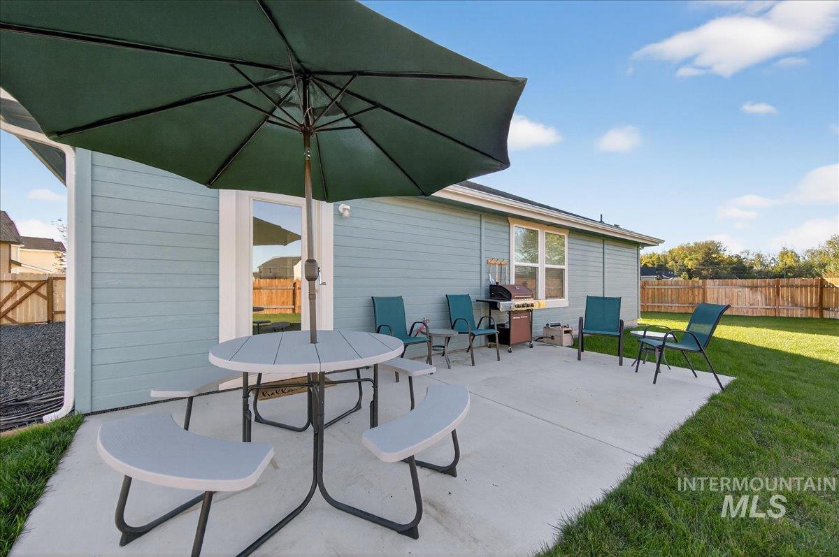 View of patio with a grill and outdoor dining area