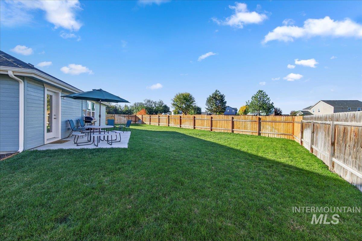 Fenced backyard with a patio area and a playground