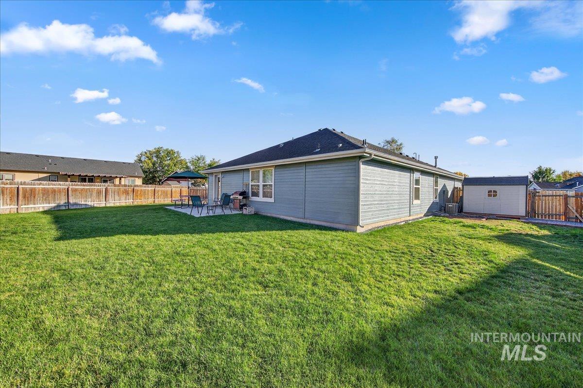 Back of house with a fenced backyard and a patio area