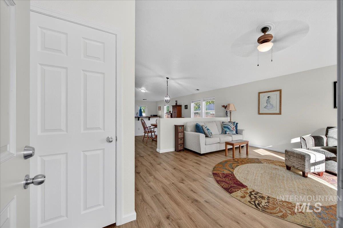 Living room with light wood-style flooring and ceiling fan