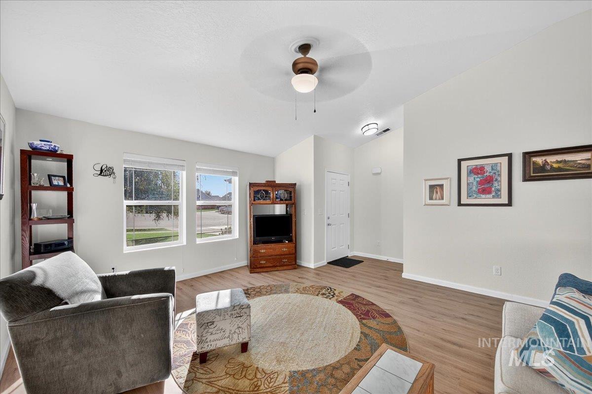 Living area with light wood-type flooring and a ceiling fan
