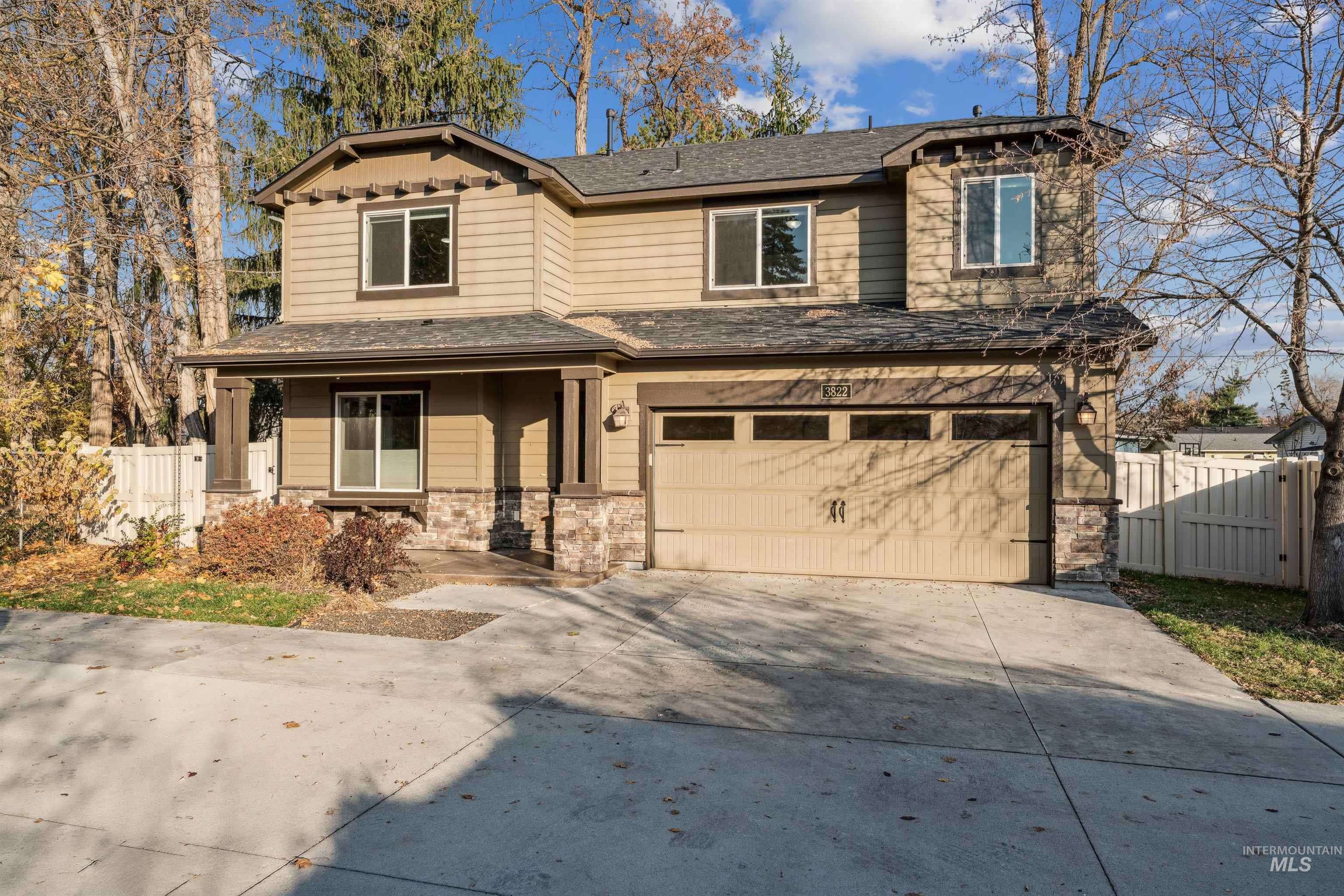 View of front facade with concrete driveway, covered porch, an attached garage, stone siding, and a shingled roof