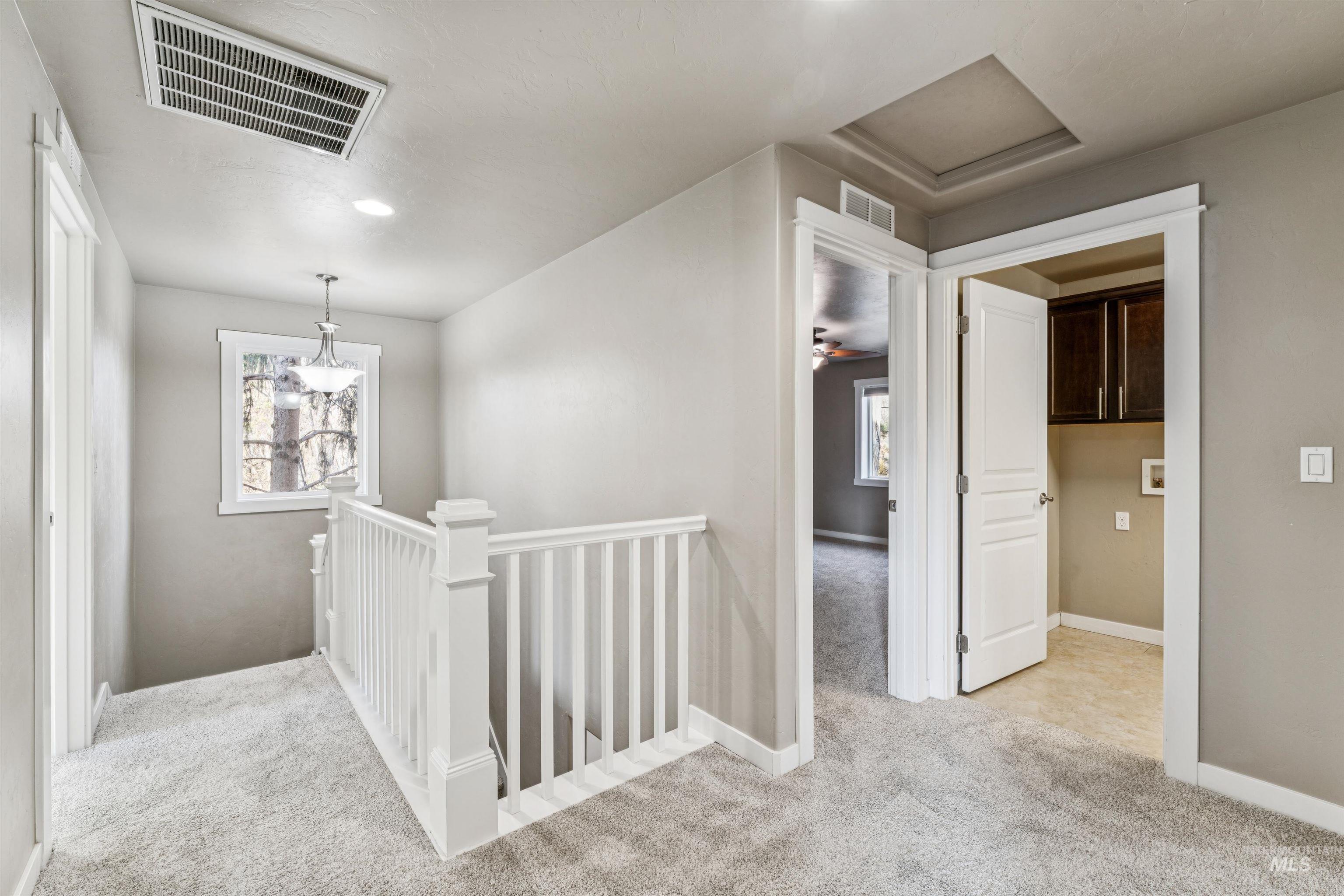 Hallway featuring an upstairs landing, light colored carpet, attic access, healthy amount of natural light, and recessed lighting