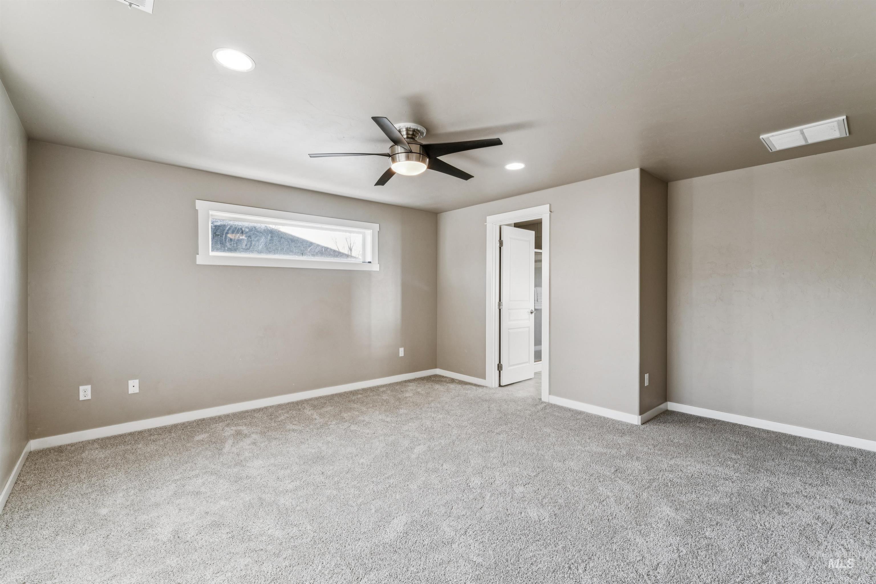 Empty room with light carpet, a ceiling fan, and recessed lighting