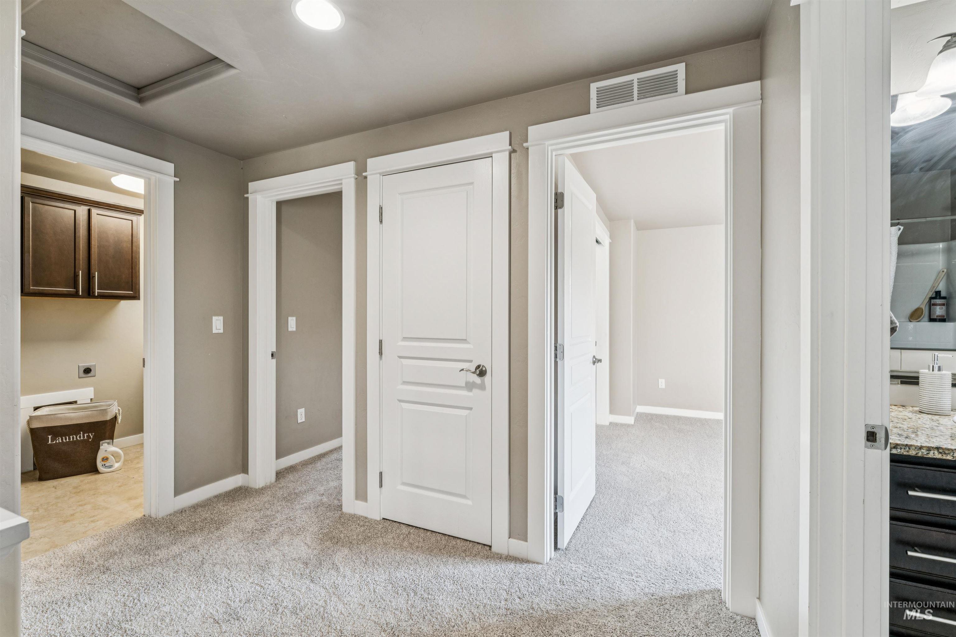 Hallway featuring attic access, light colored carpet, and recessed lighting
