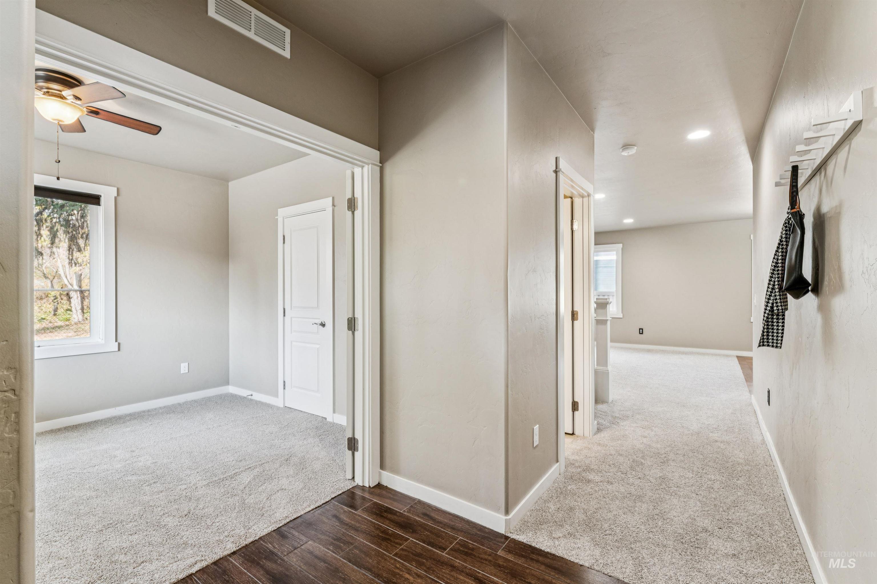 Corridor with carpet flooring, wood finished floors, and recessed lighting