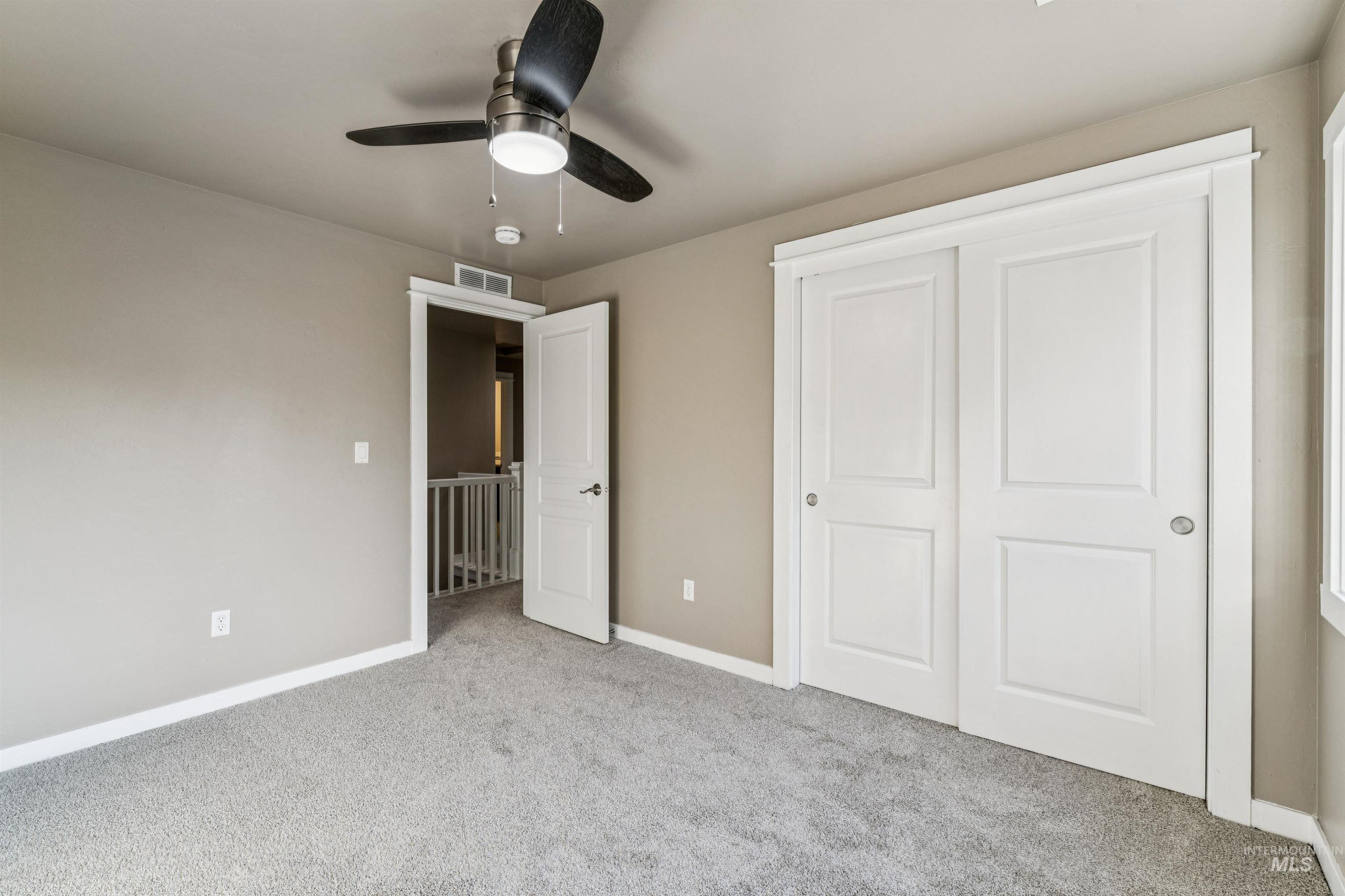 Unfurnished bedroom featuring carpet, a closet, and ceiling fan