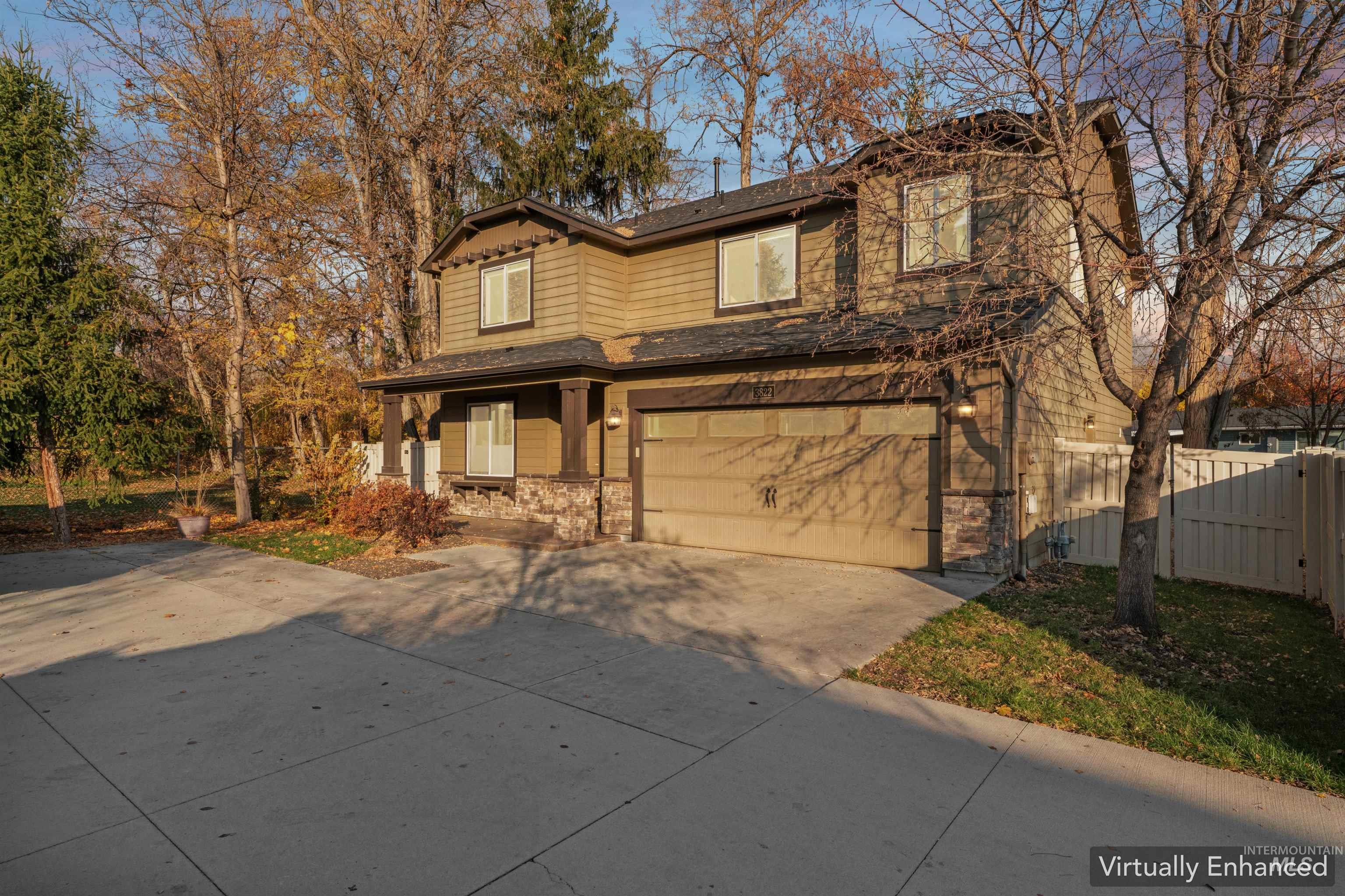 View of front facade featuring concrete driveway, a garage, stone siding, and covered porch