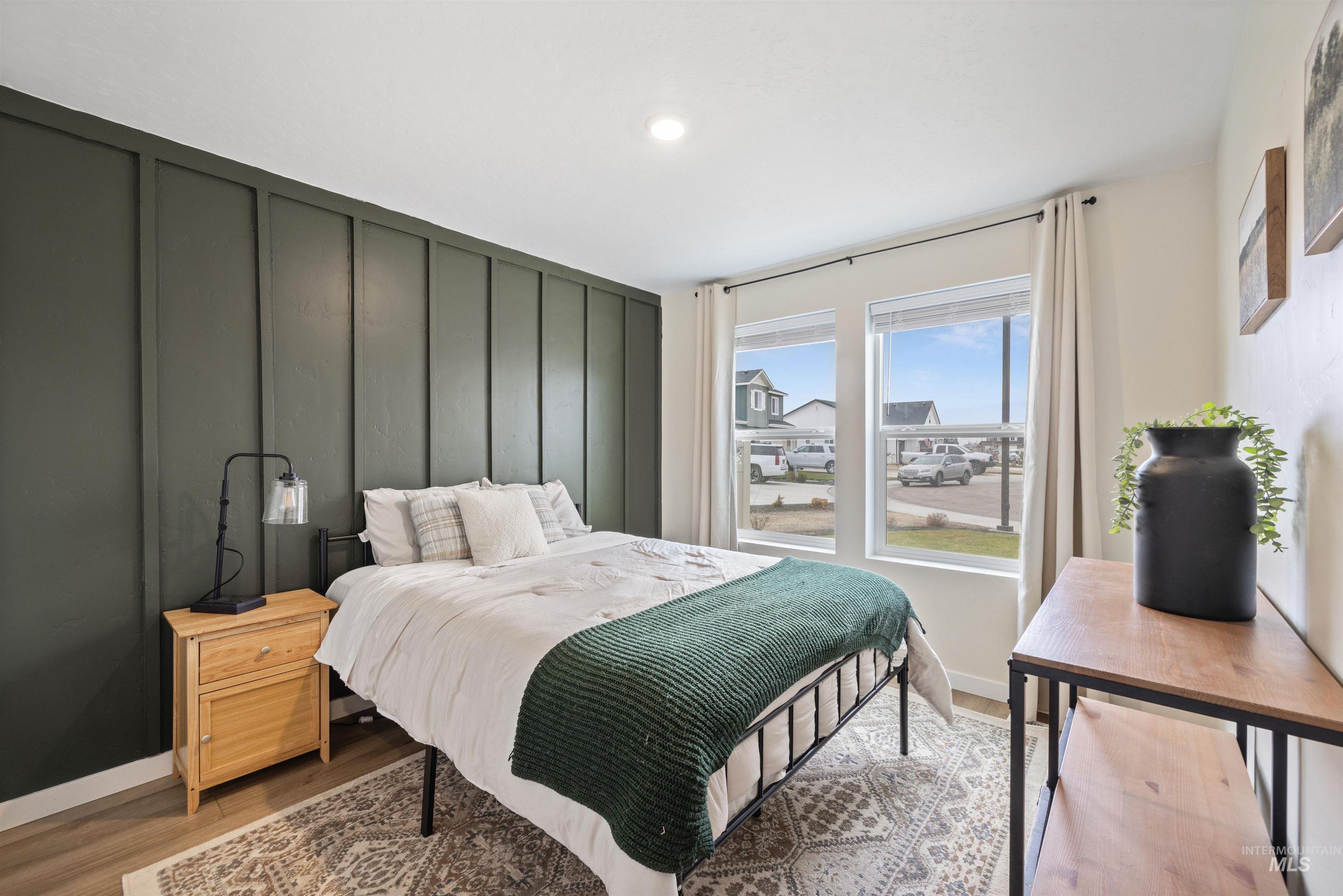 Bedroom featuring a decorative wall, light wood-style floors, and recessed lighting