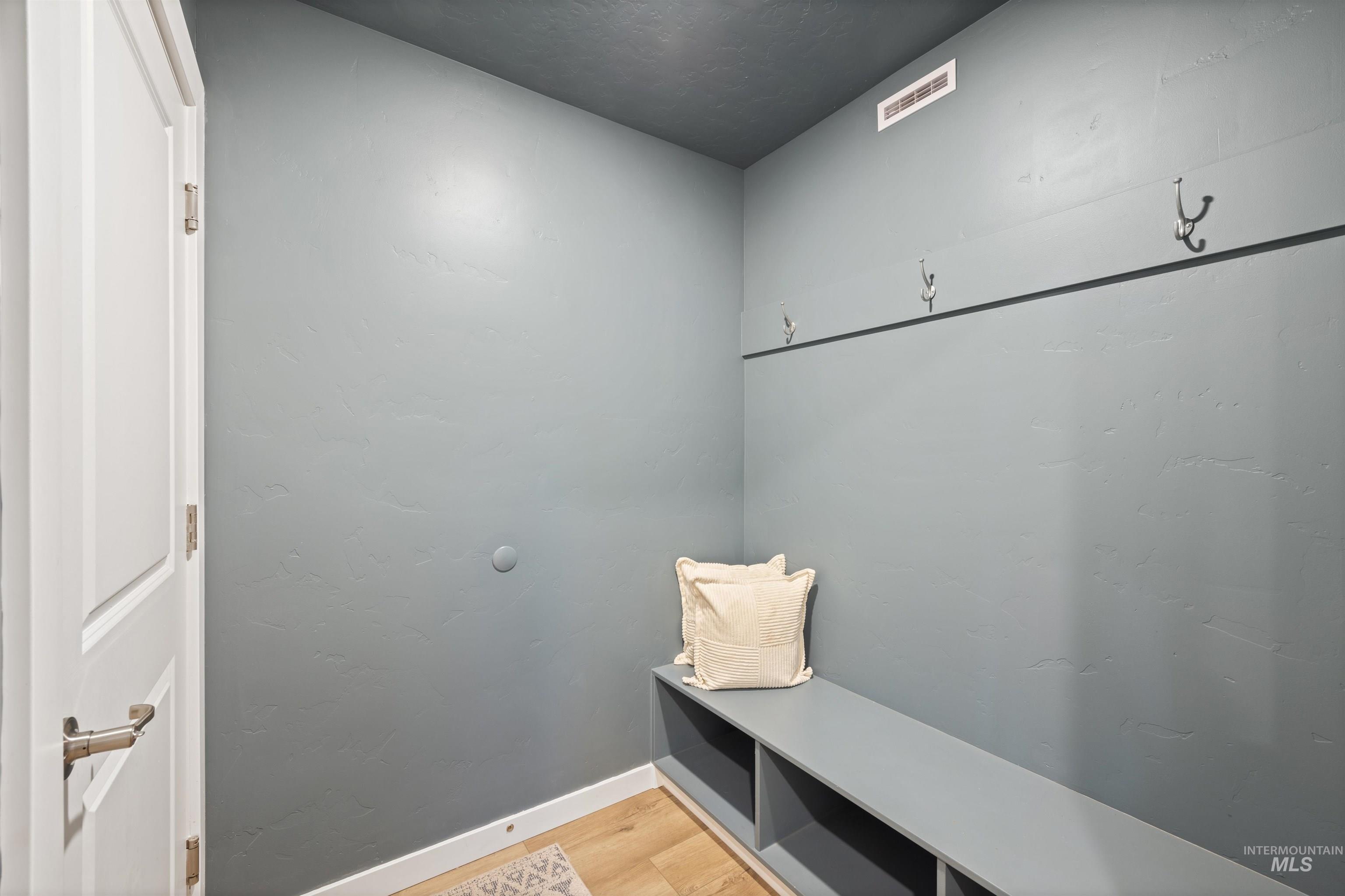 Mudroom with light wood-style floors and a textured wall