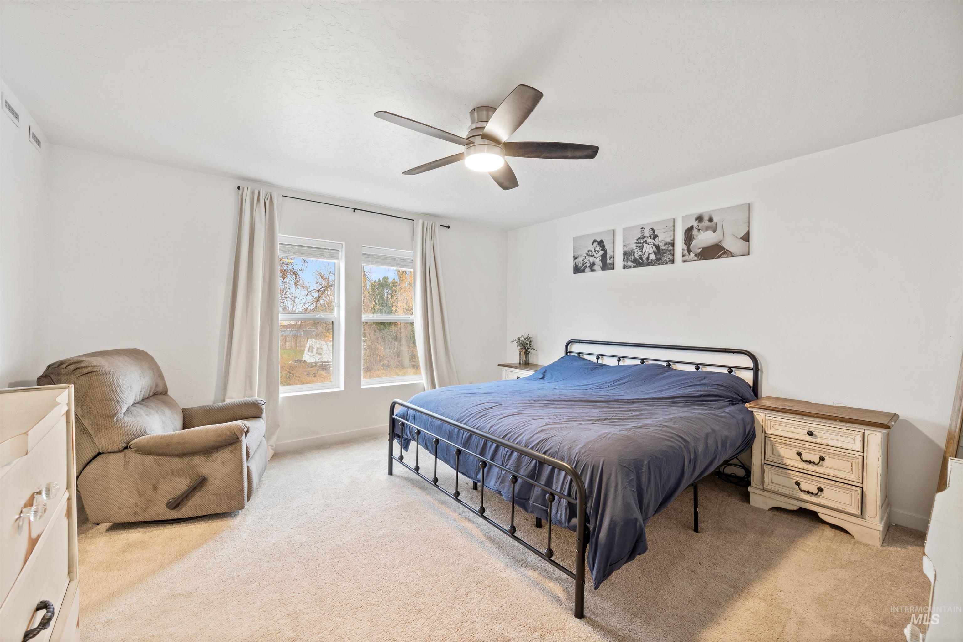 Bedroom featuring light carpet and a ceiling fan