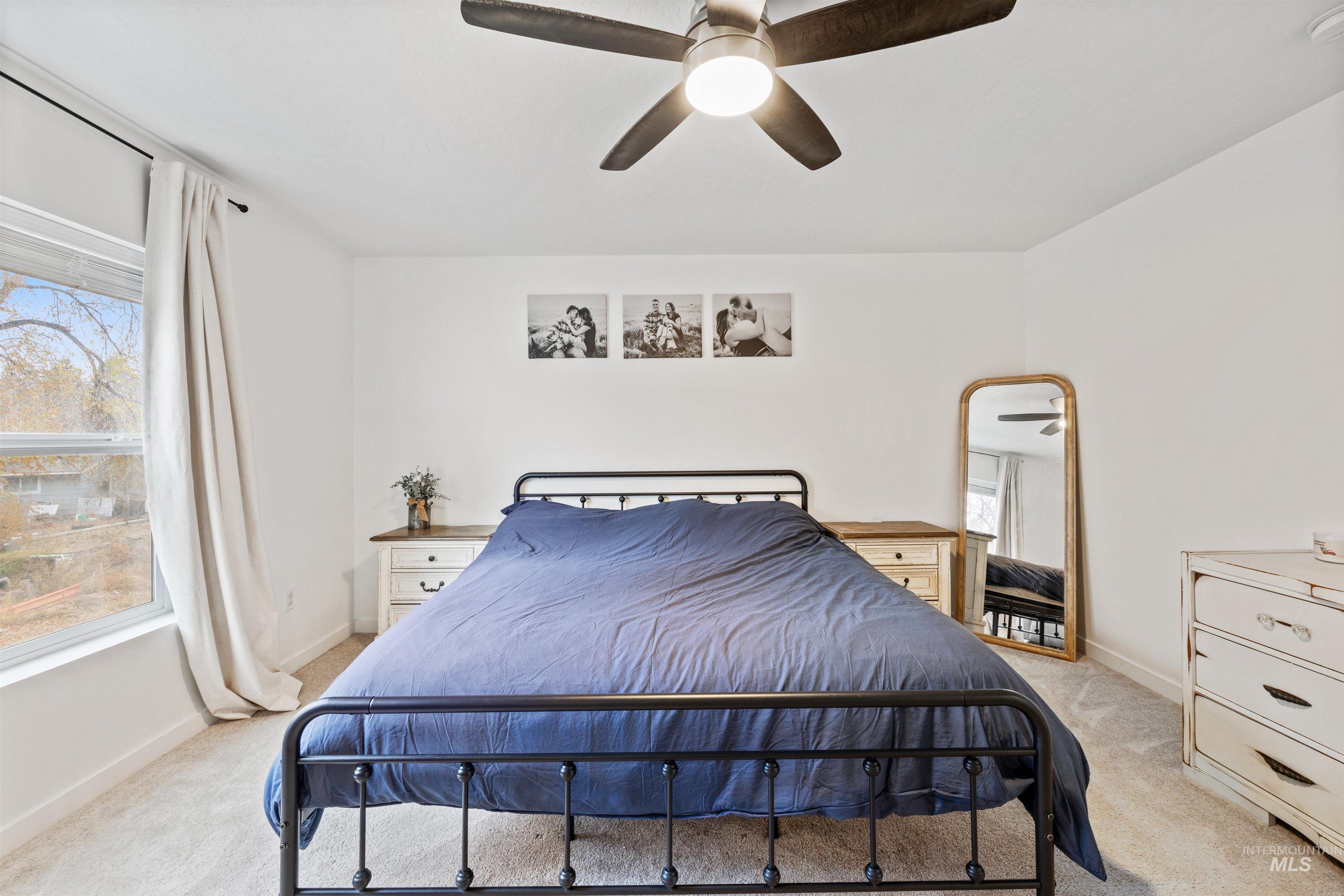 Bedroom featuring light colored carpet and a ceiling fan