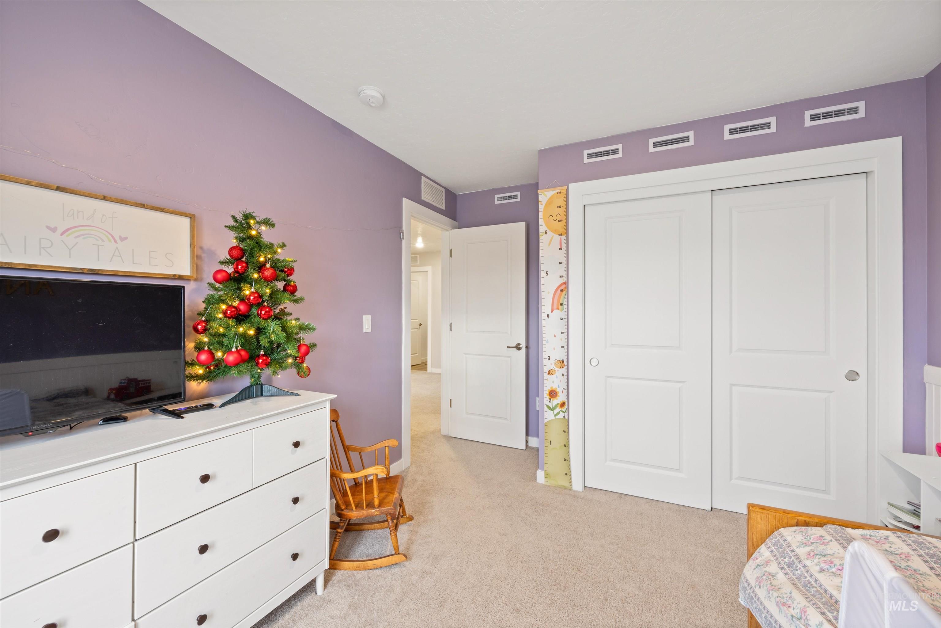 Bedroom featuring light colored carpet and a closet