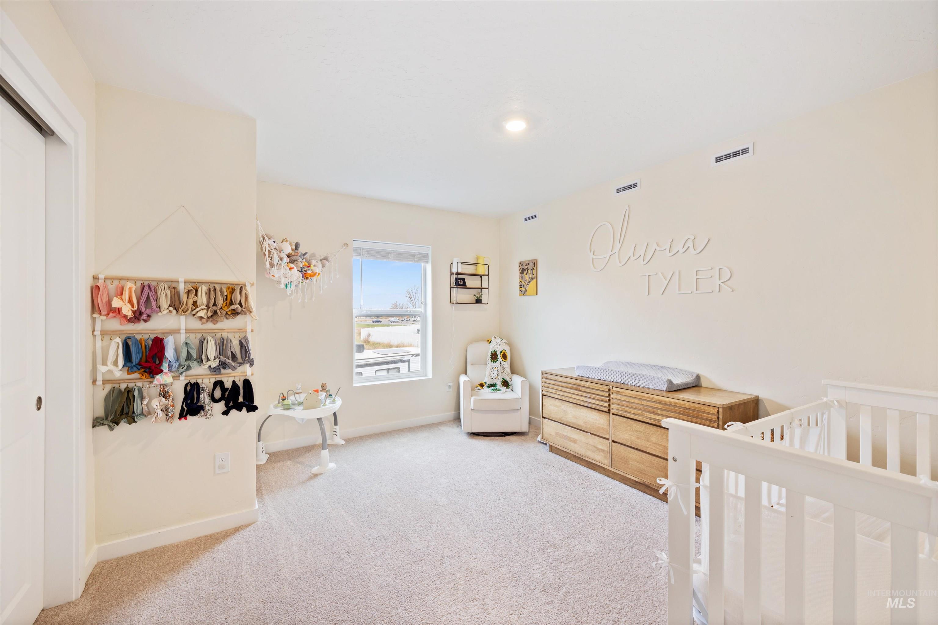 Bedroom with a nursery area, carpet, and a closet