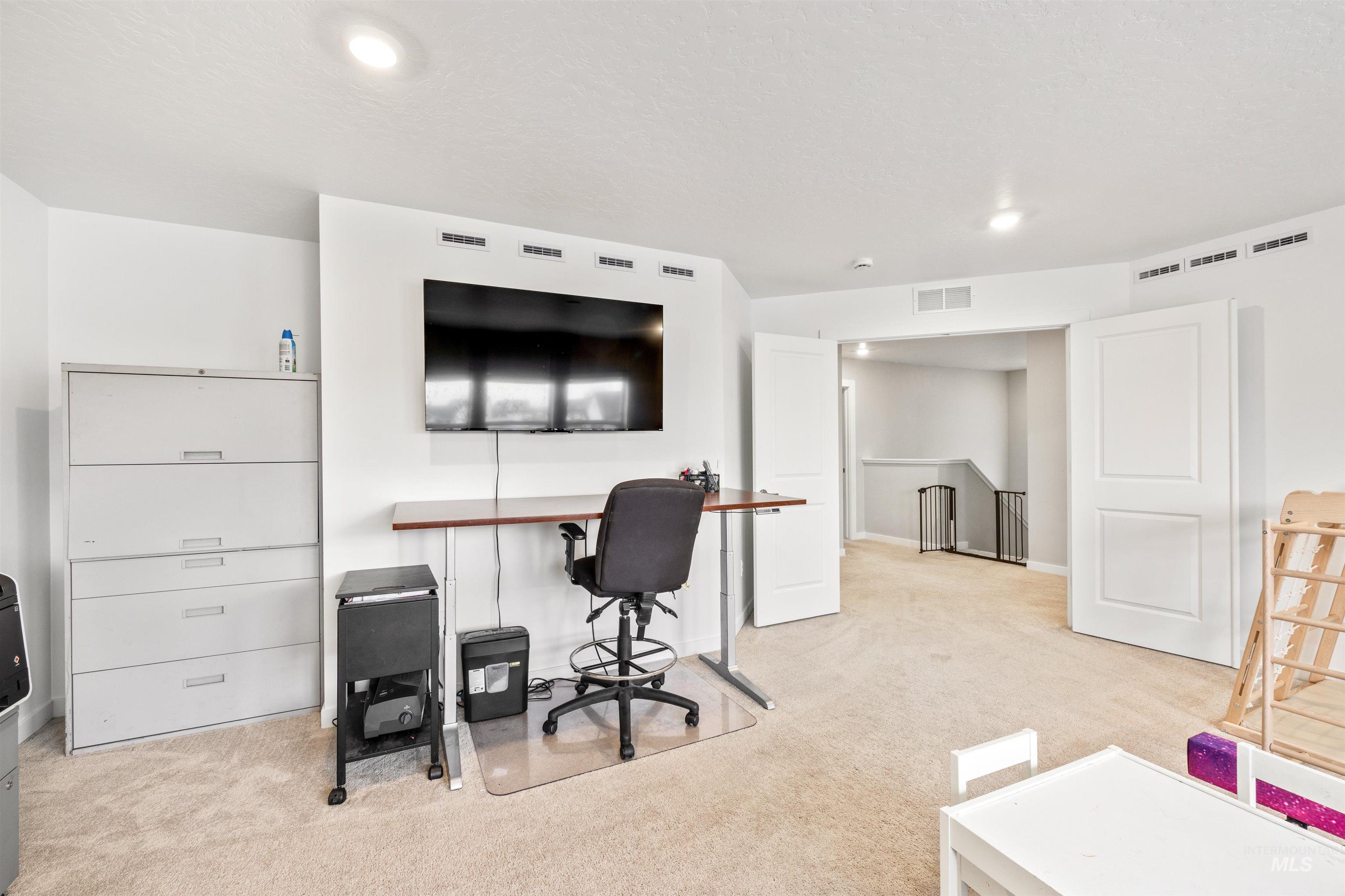 Office space featuring light colored carpet and recessed lighting